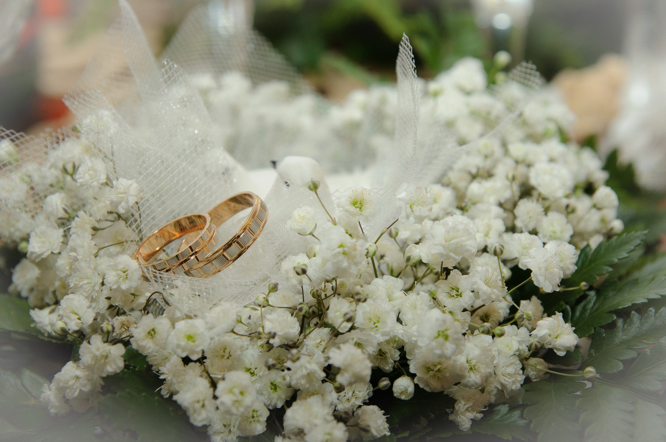 Свадебные кольца на букете белых цветов