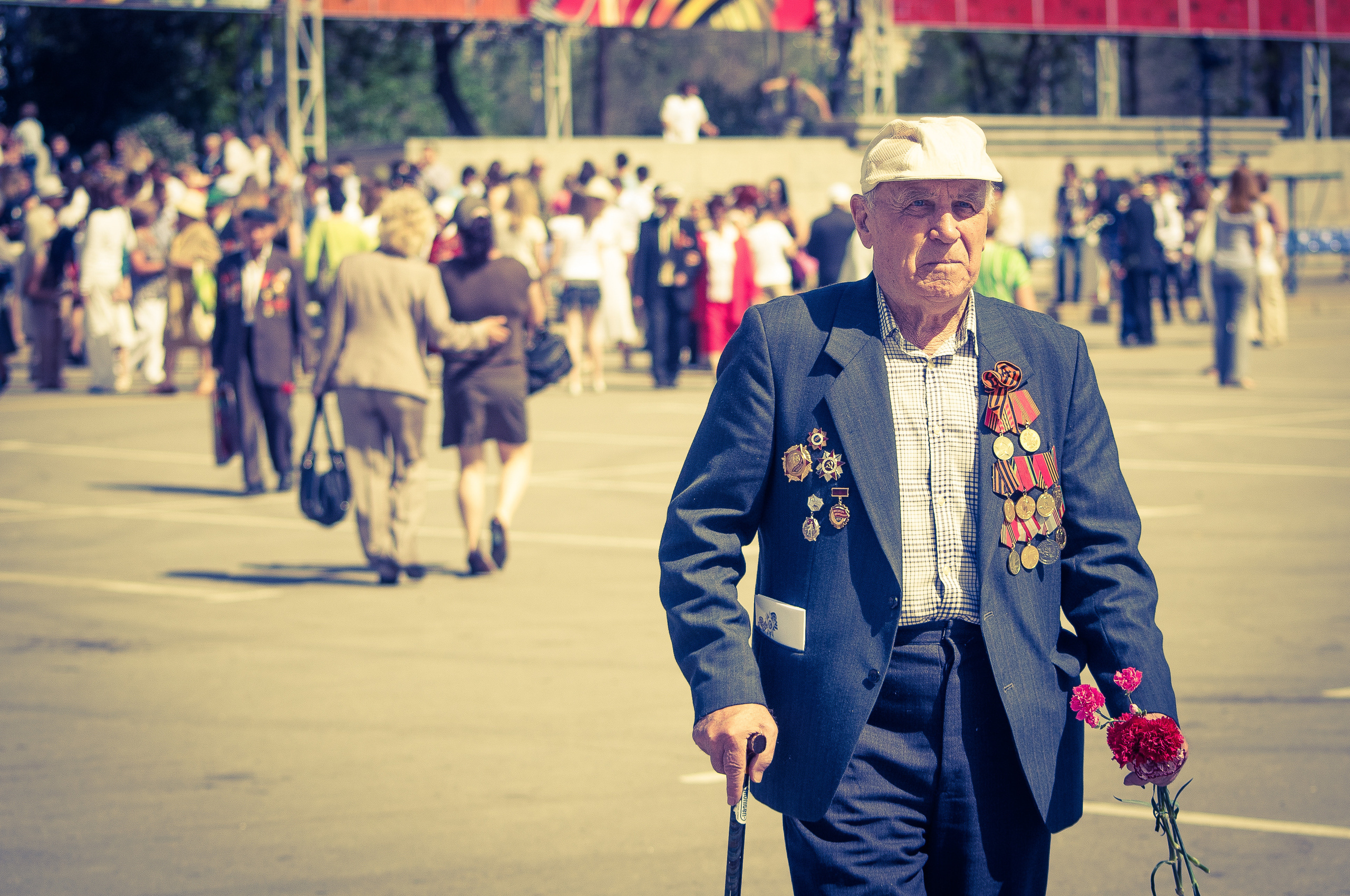 Ветеран с цветами в руках на параде