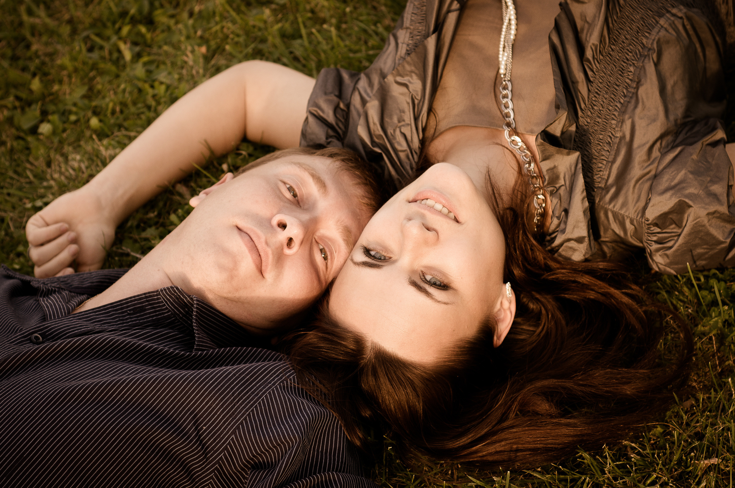 Девушка и парень лежат на земле, касаясь головами