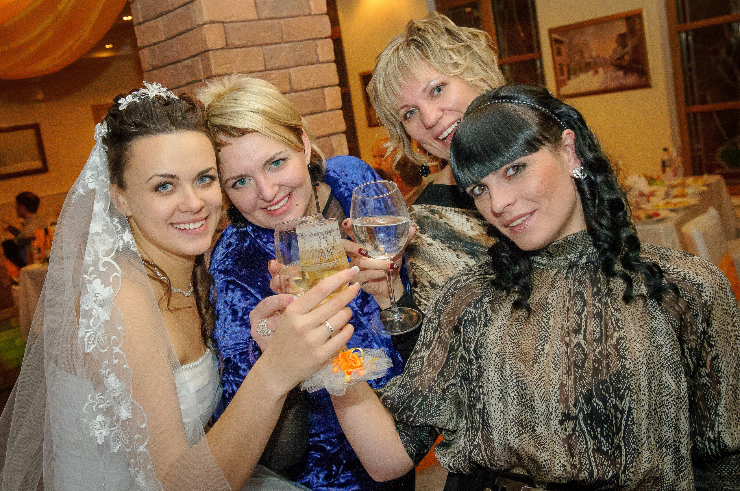 Невеста со своими подругами в ресторане с бокалами шампанского в руках