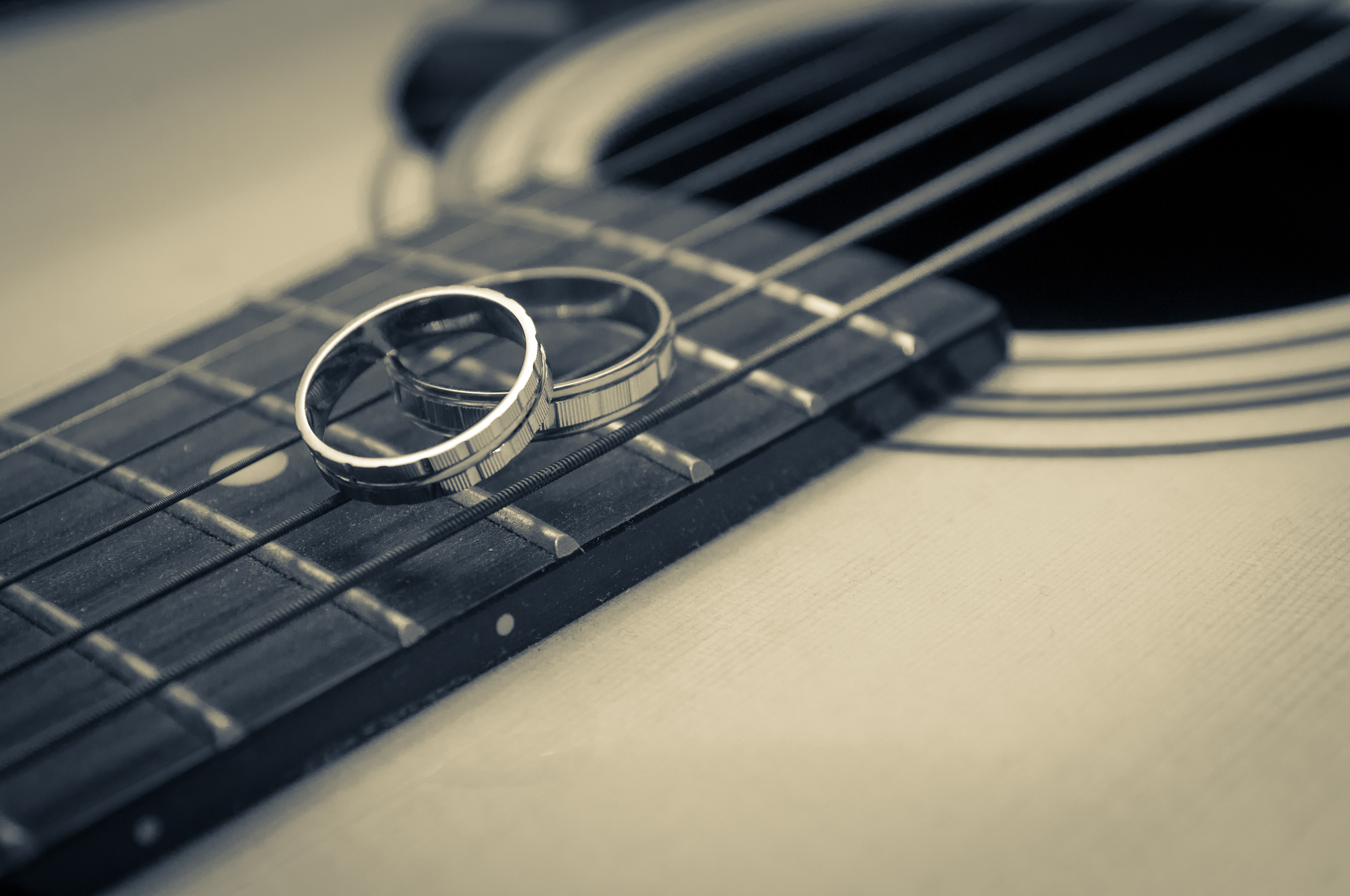 Обручальные кольца лежат на грифе гитары