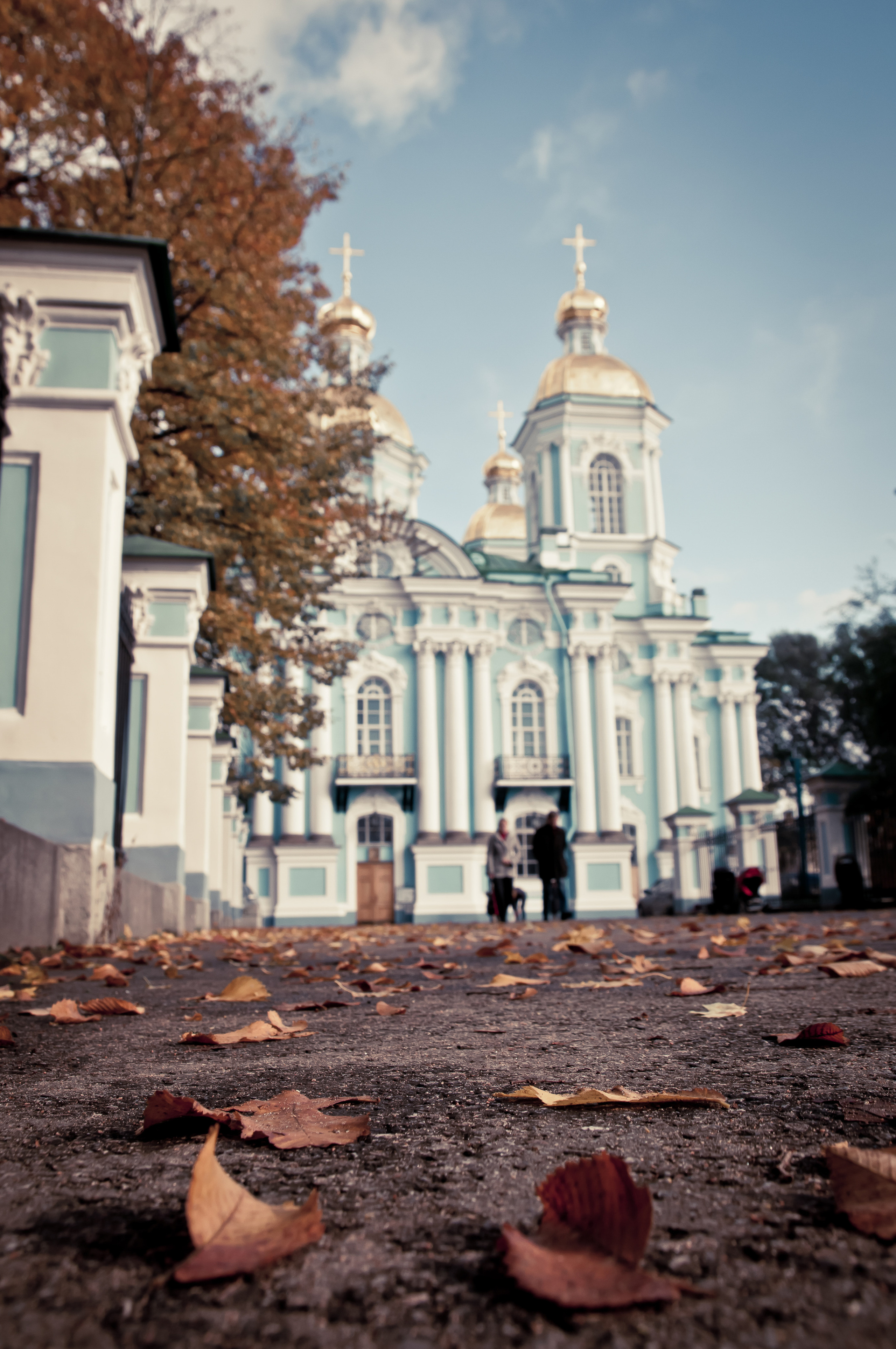 Осенние листья лежат на асфальте перед храмом в Санкт-Петербурге