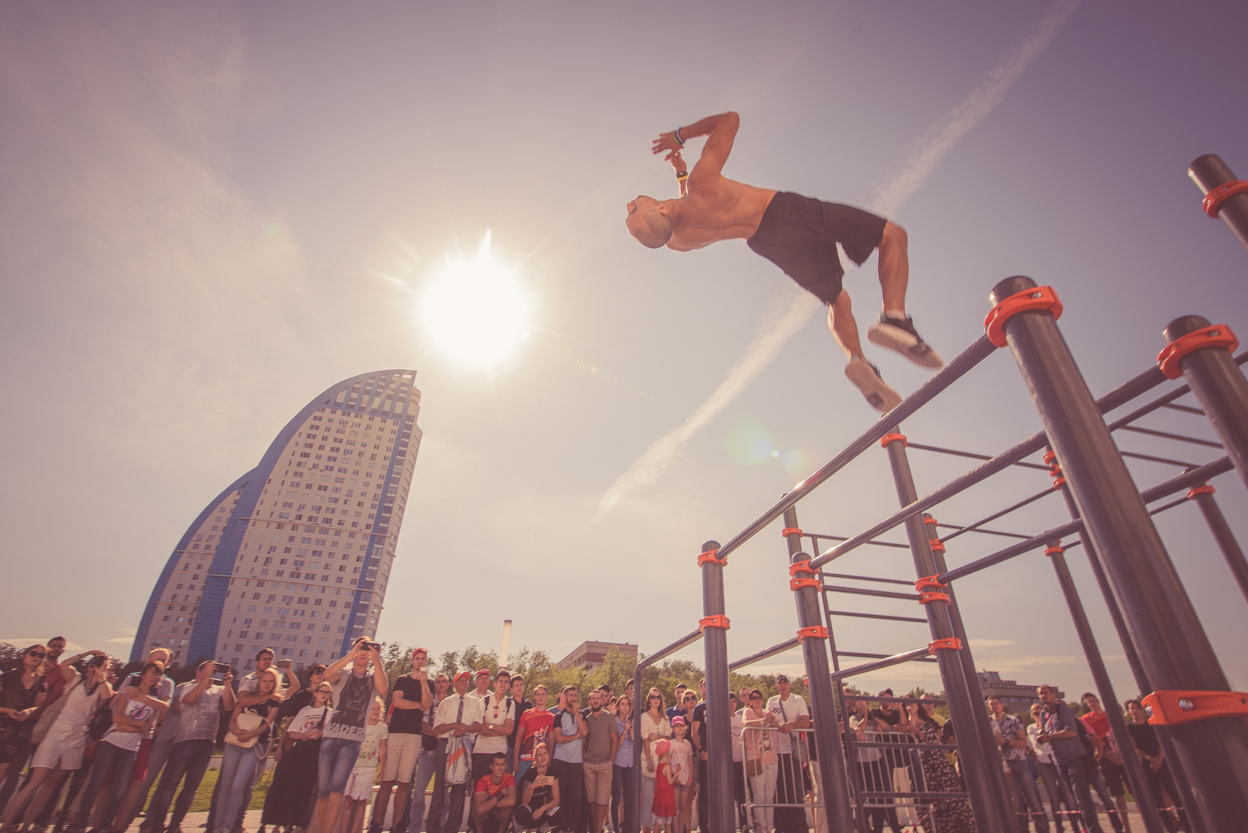 Спортсмен делает сальто с брусьев  на соревнованиях по воркауту
