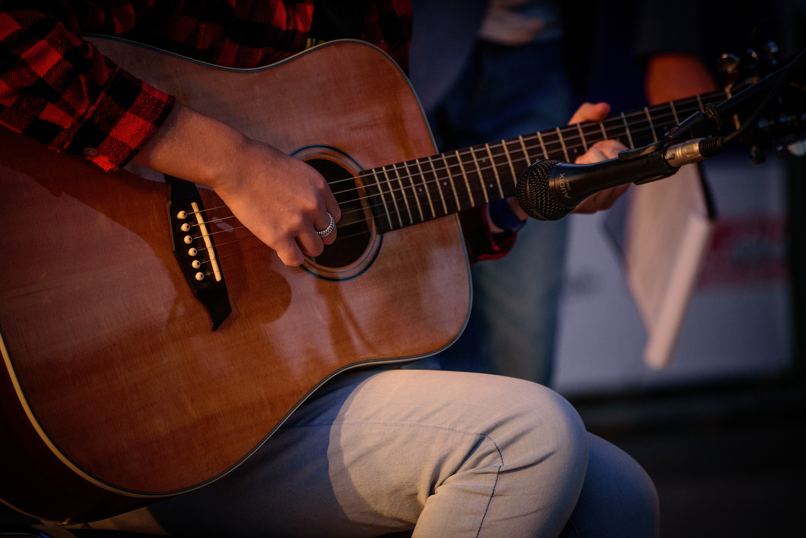 Гитарист играет на гитаре, стоящей на колене