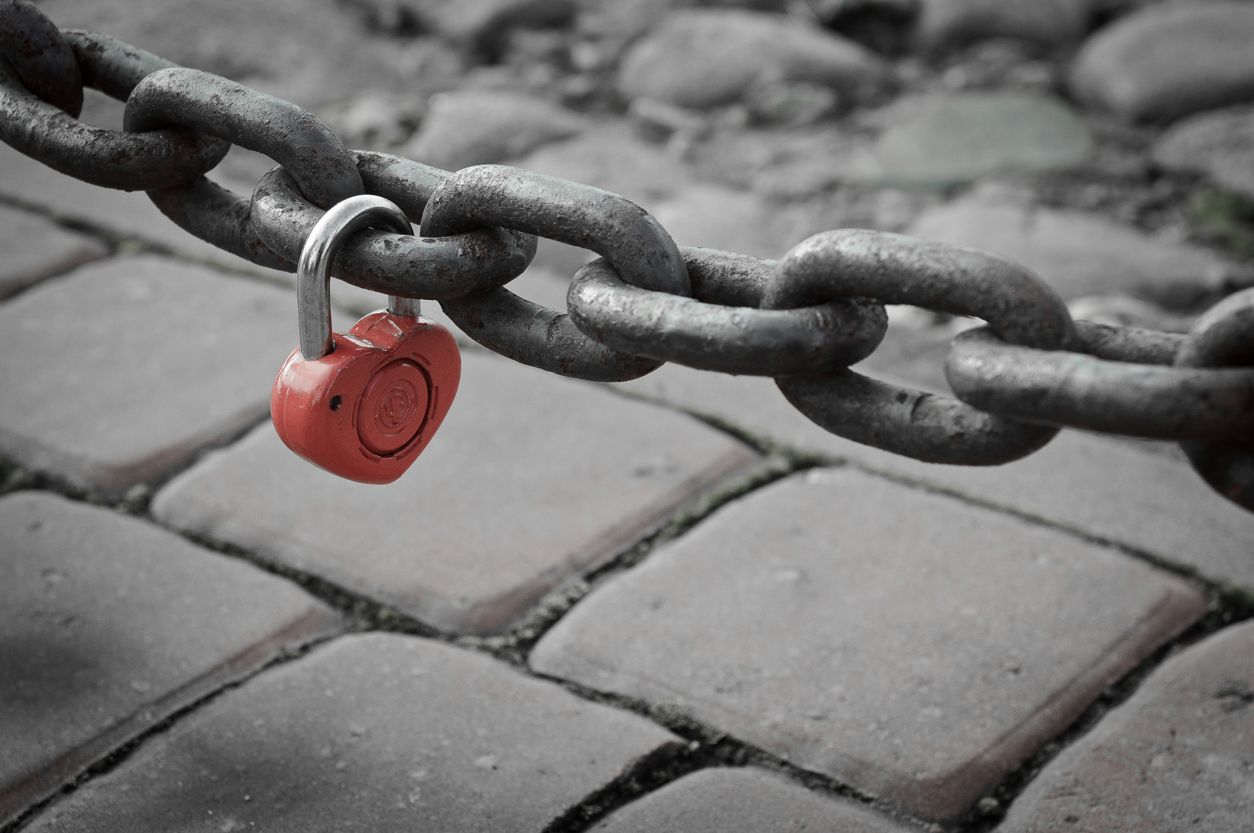 Красный замок в виде сердца висит на толстой цепи