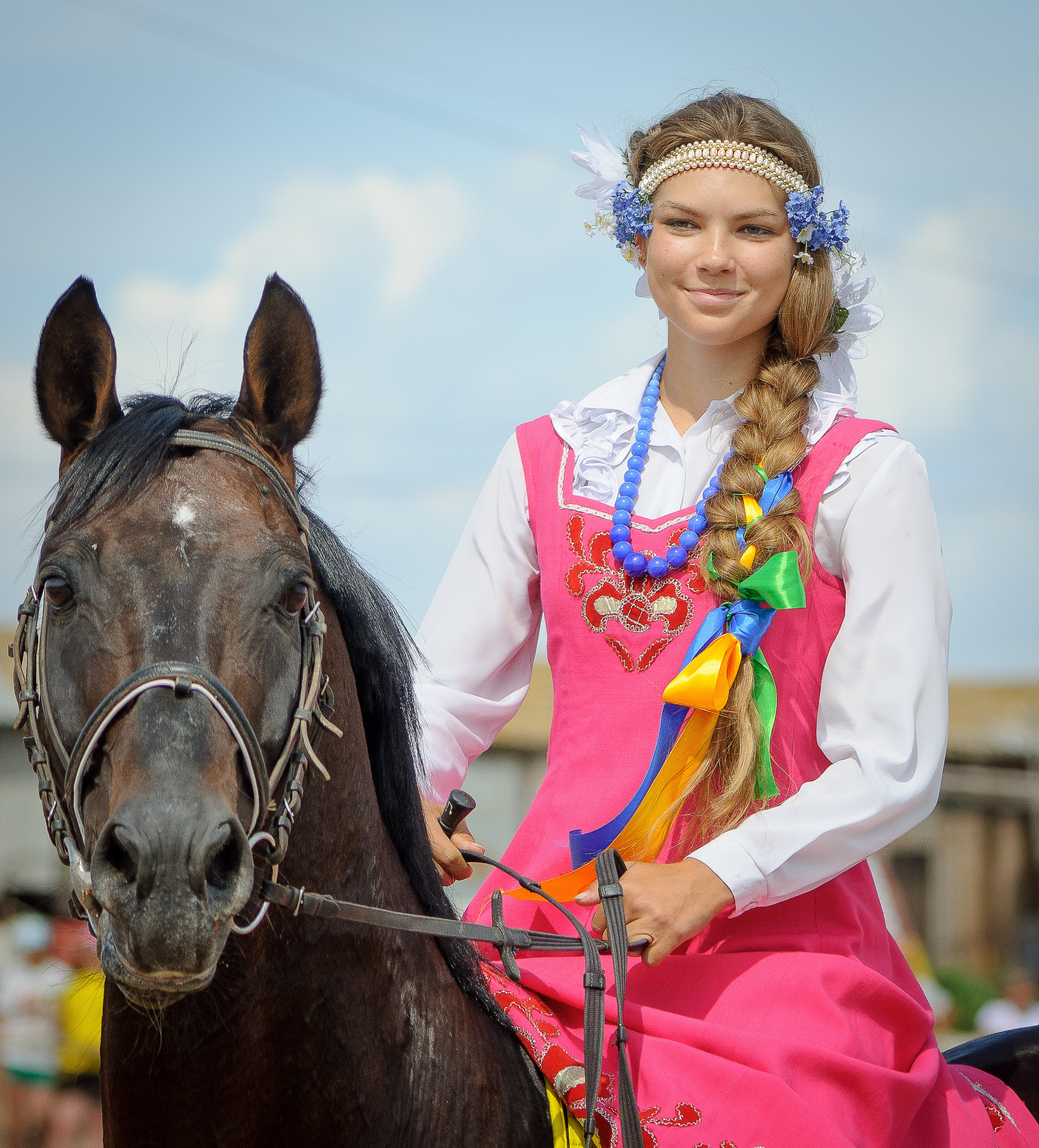 Улыбающаяся девушка в русском наряд верхом на коне