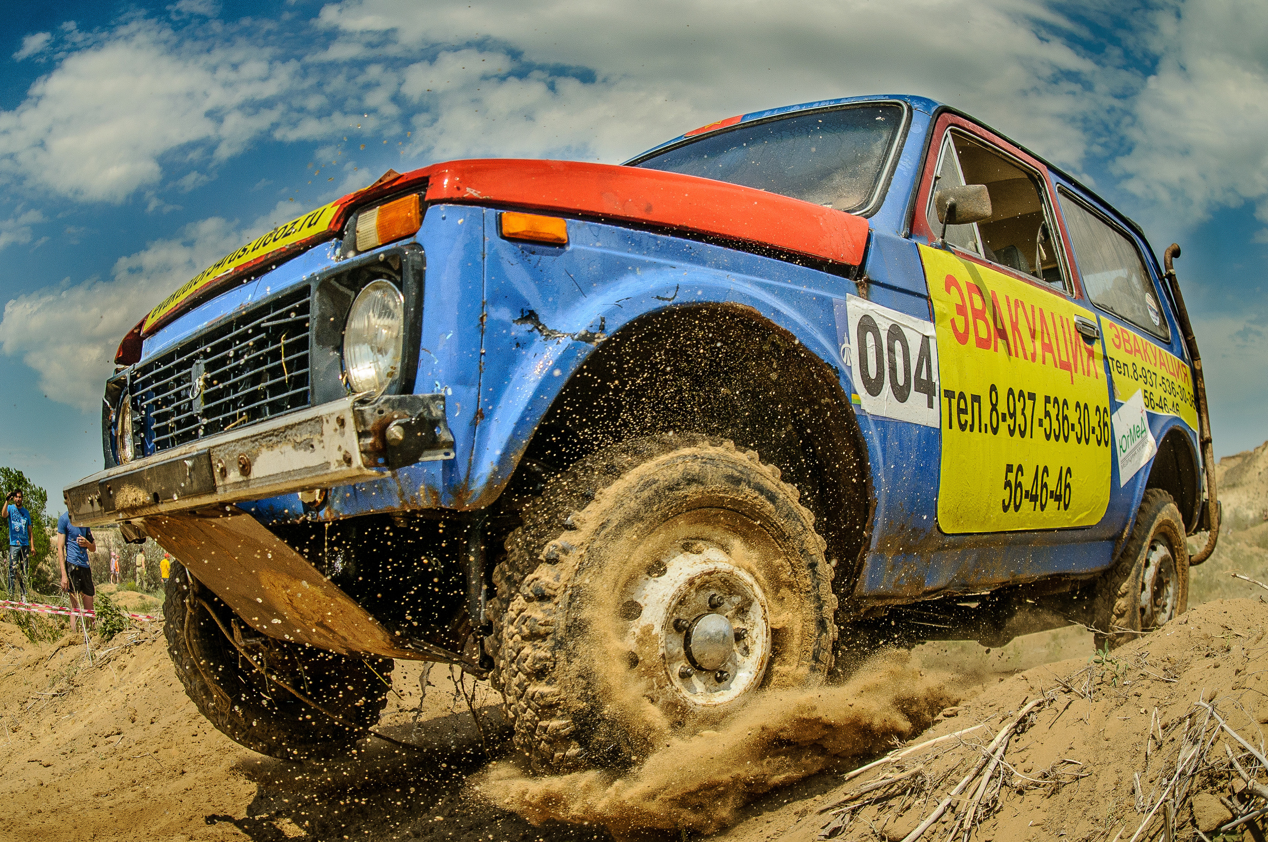 Автомобиль Нива, из-под колёс летит песок и земля