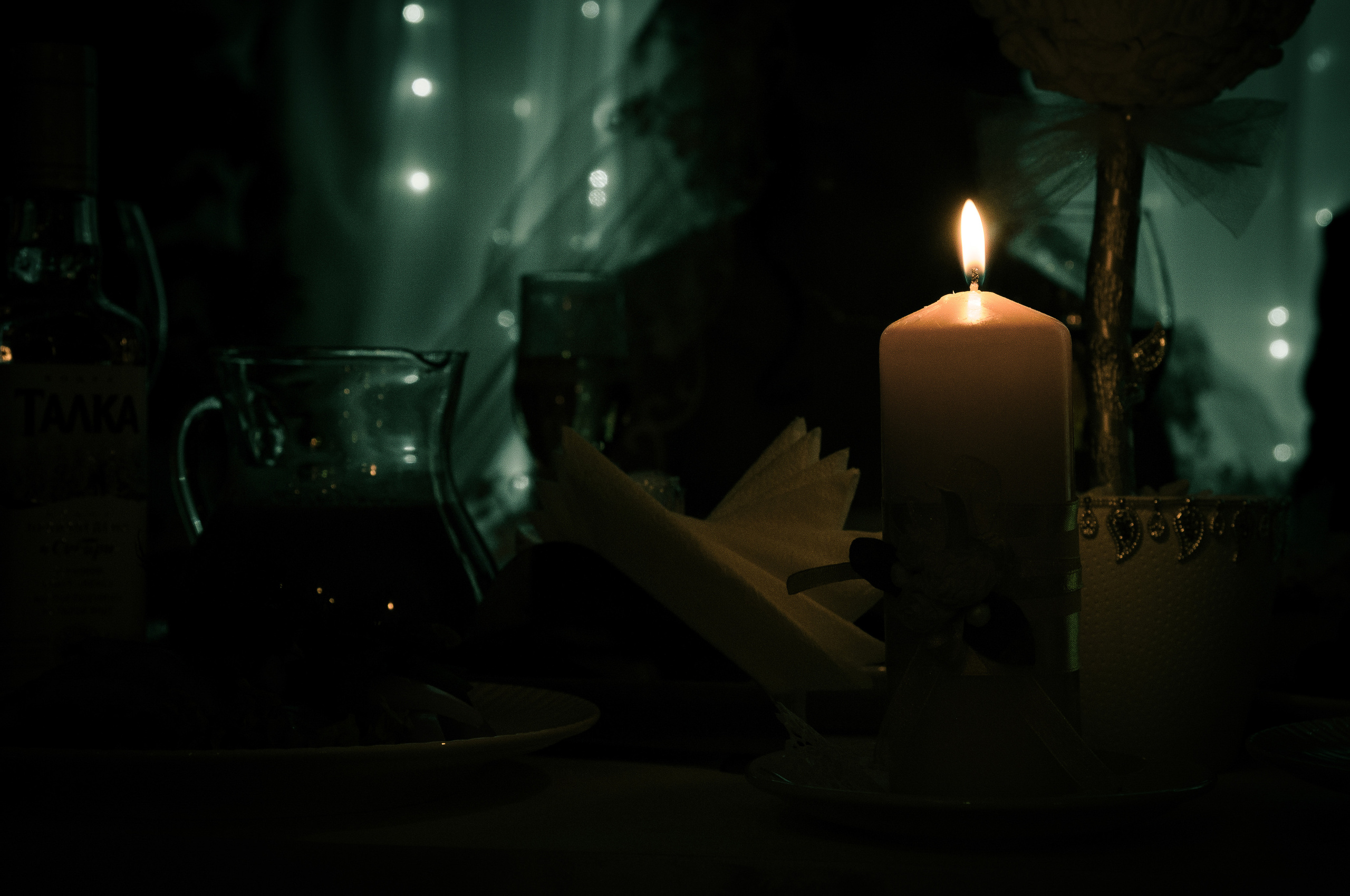 Свеча горит в полумраке на столе