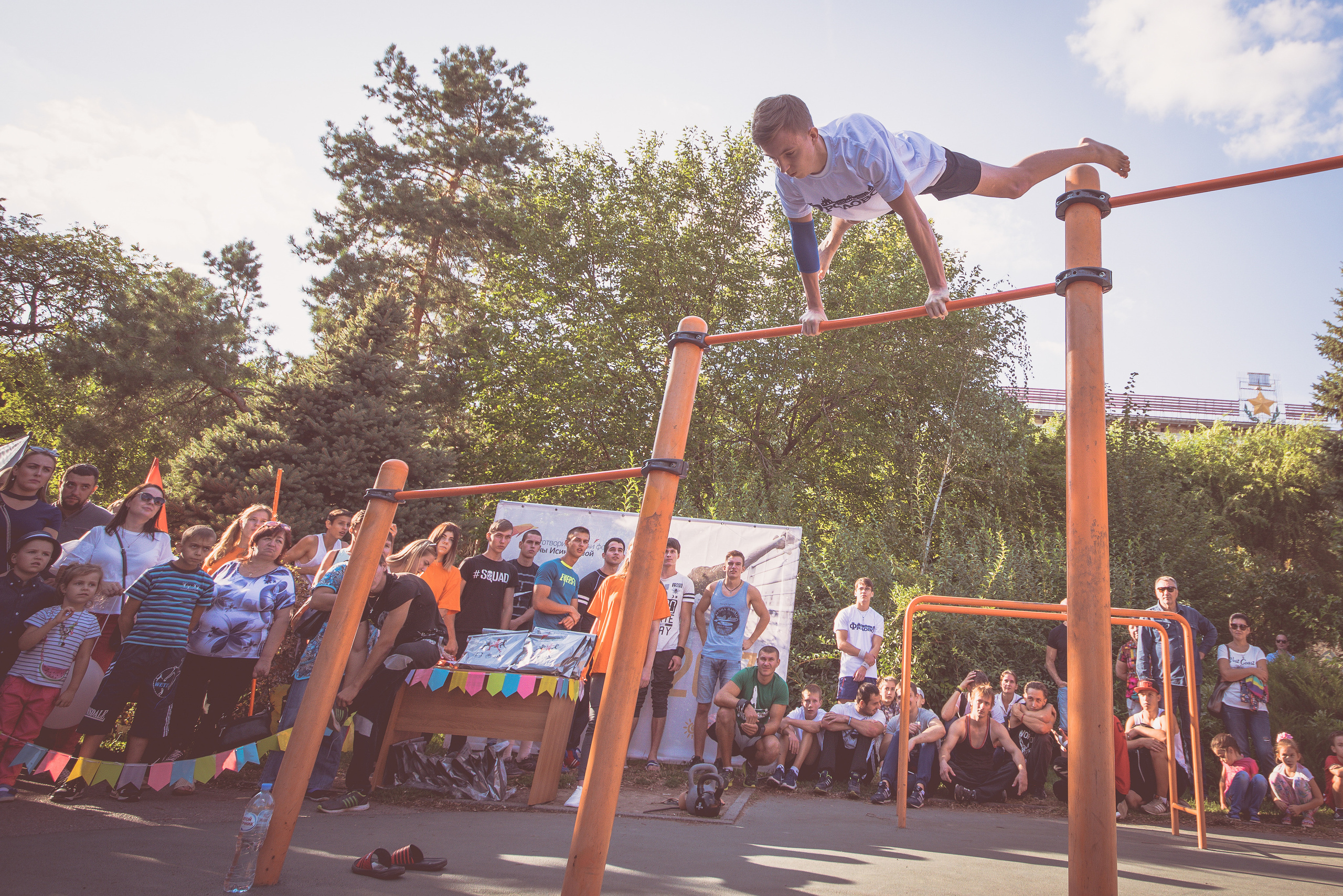 Спортсмен на турнике показывает силовой элемент