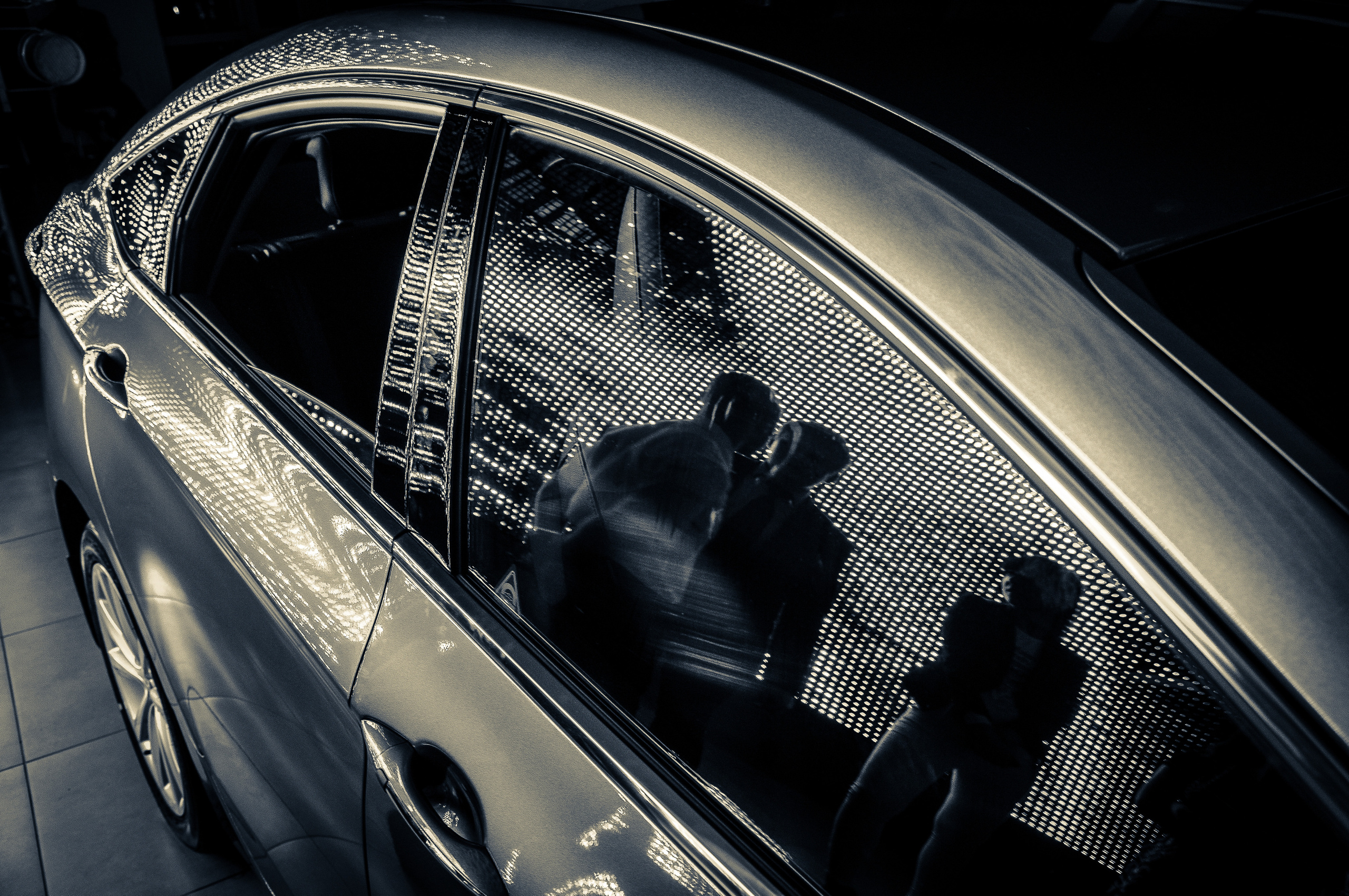 Контуры людей в отражении на стекле автомобиля