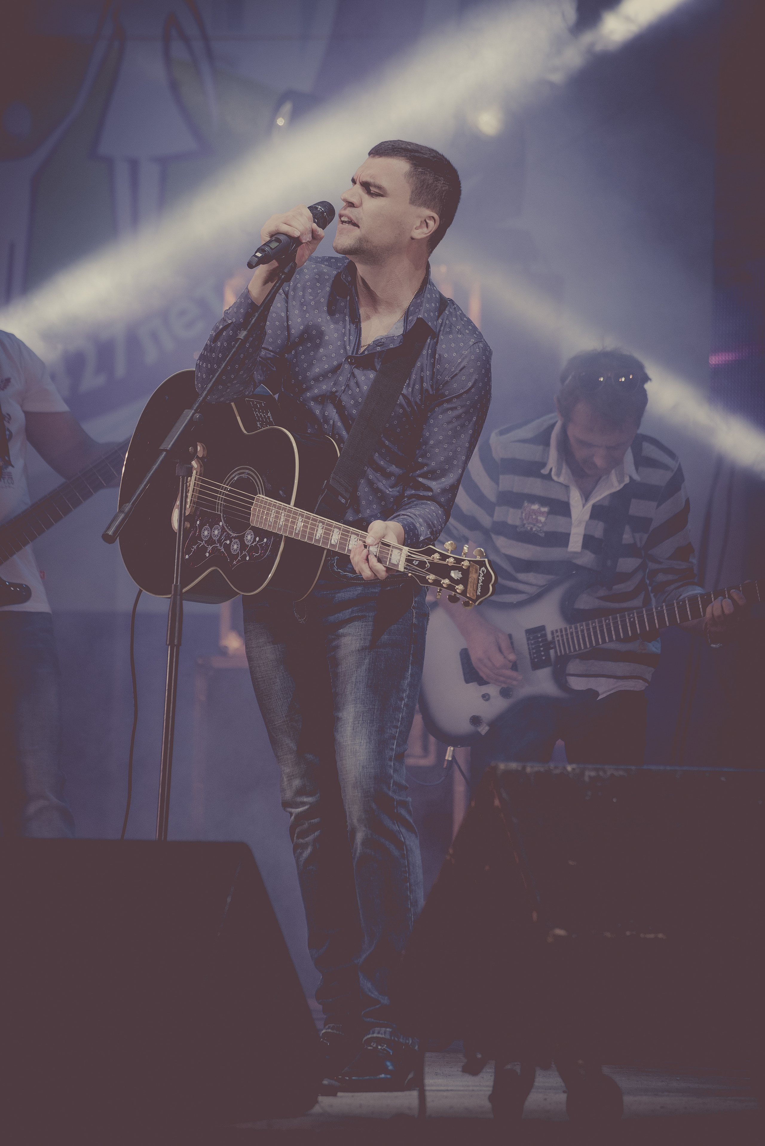 Певец с гитарой поёт у микрофона