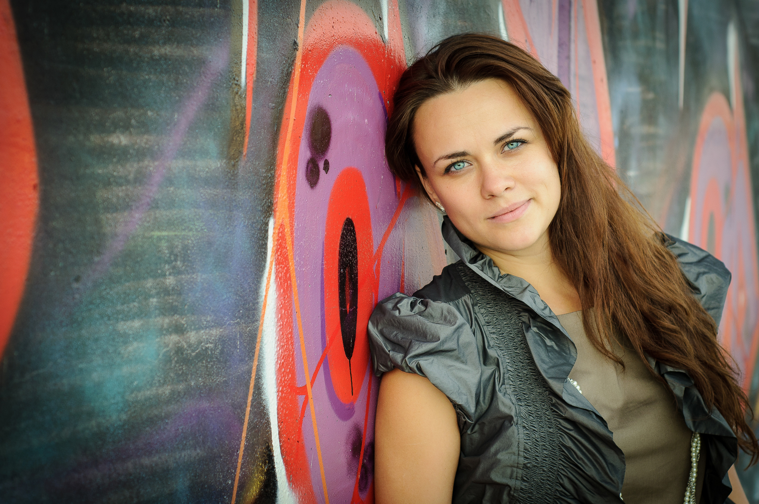 Девушка стоит у стены с граффити