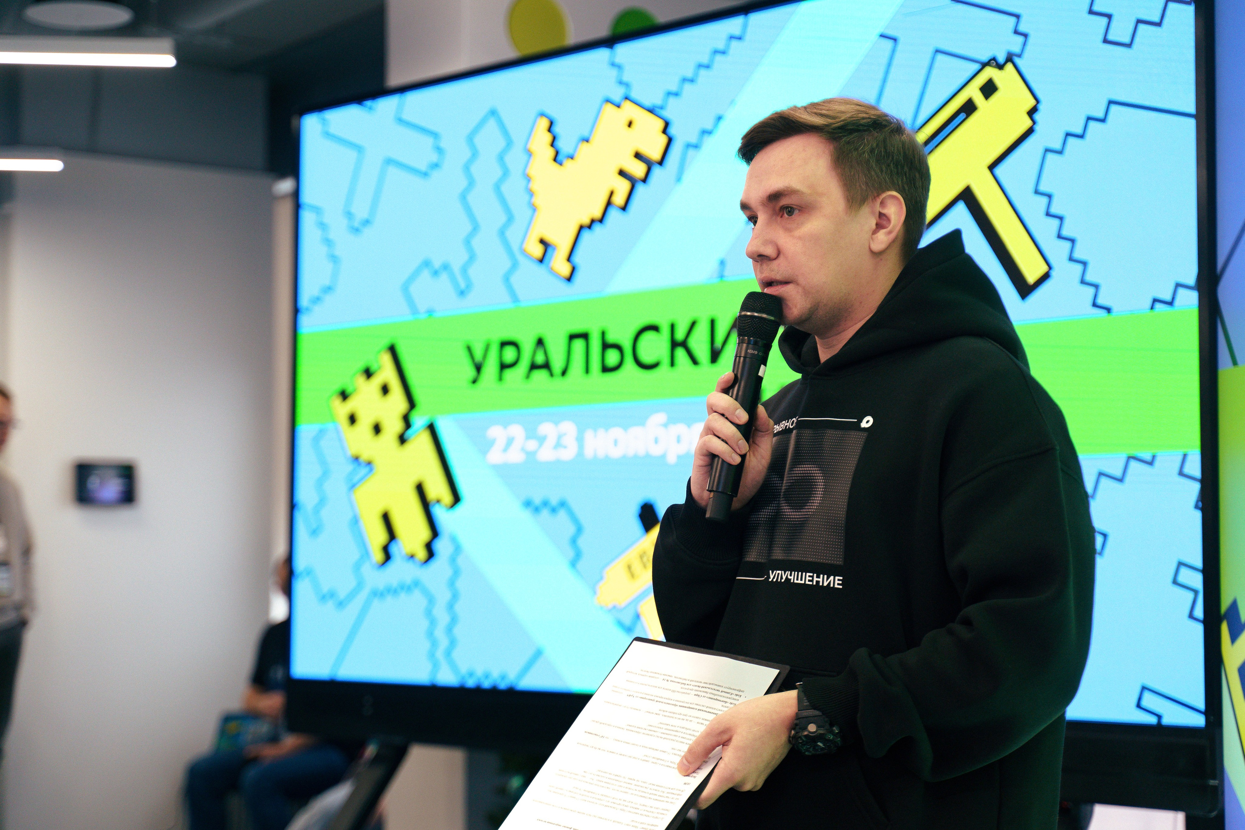 Спикер выступает на сцене хакатона Уральский код 2025