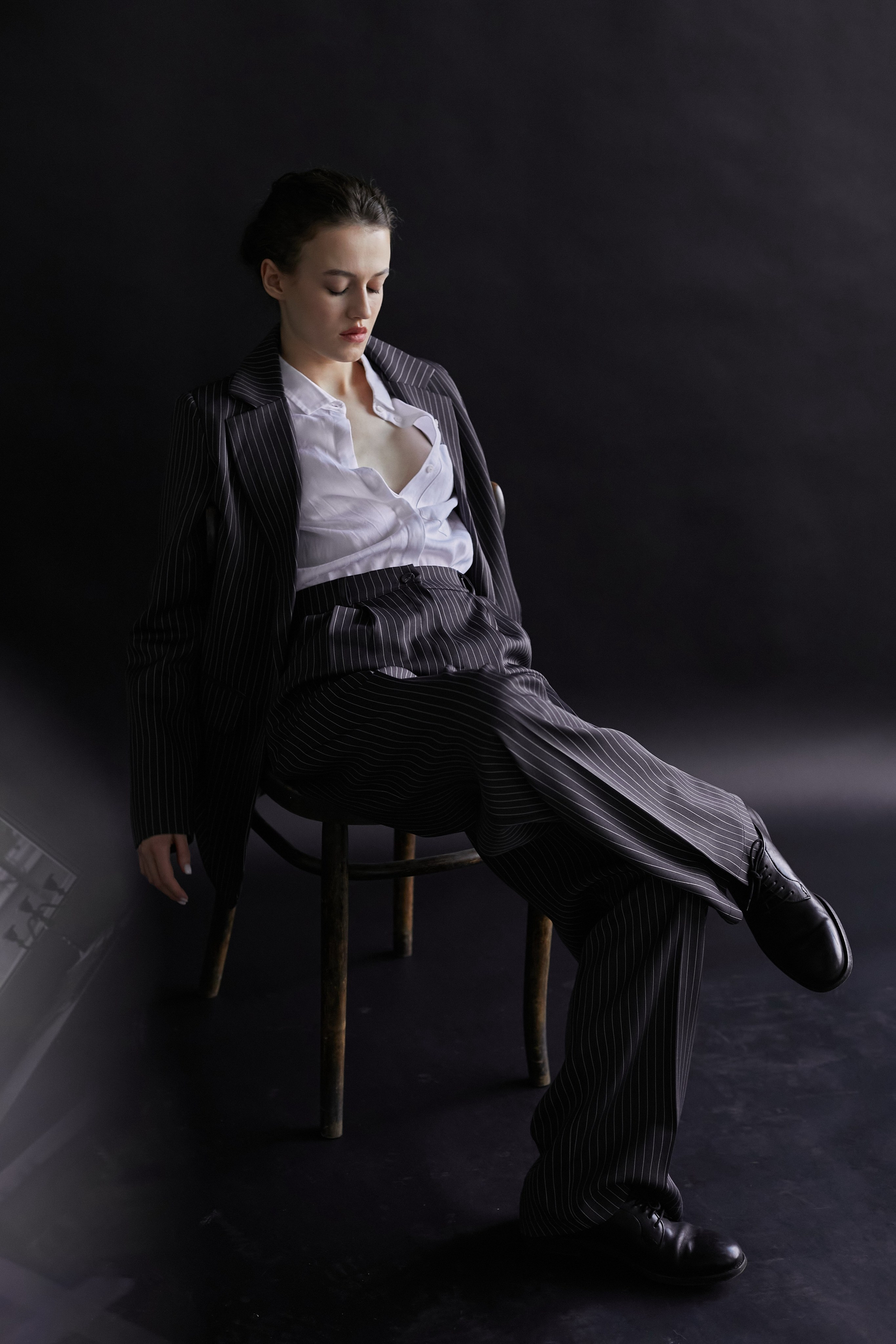 Фотограф в Москве. Студия. Студийный портрет. Девушка в пиджаке. Девушка на стуле на черном фоне. Красивая девушка в мужском костюме. Женский портрет.