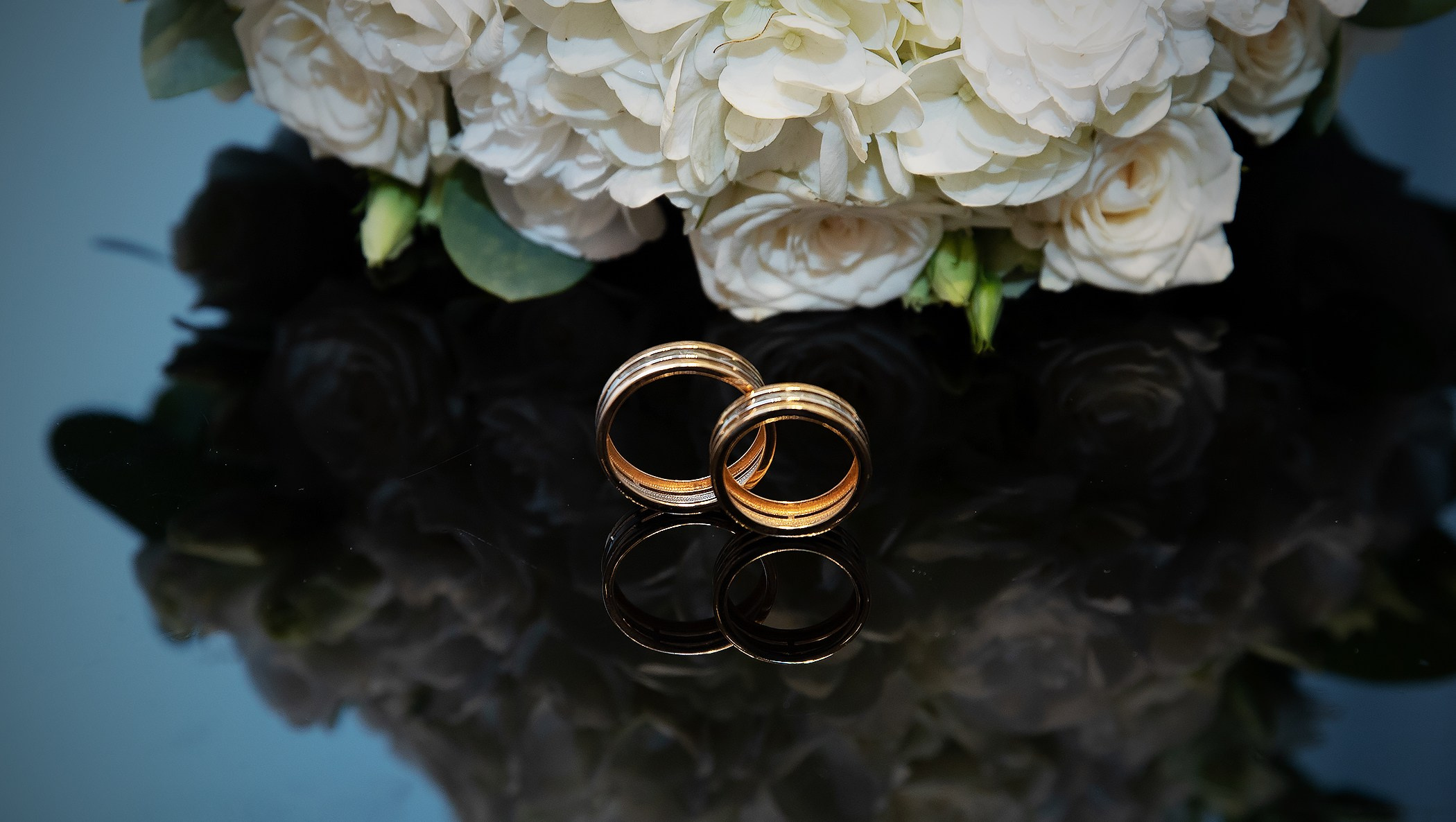 свадебная фотосессия букет белых цветов с кольцами на черном фоне