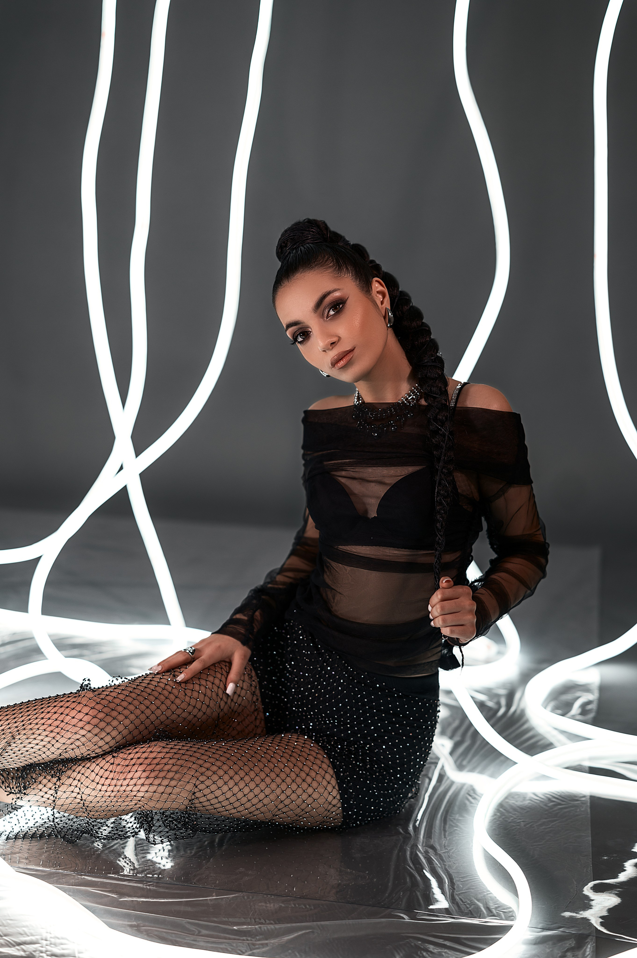 Студия, Волгодонск: женская фотосессия от Елизаветы Жуйковой. Девушка в чёрной одежде на сером фоне с неоновой подсветкой — современный минималистичный кадр.