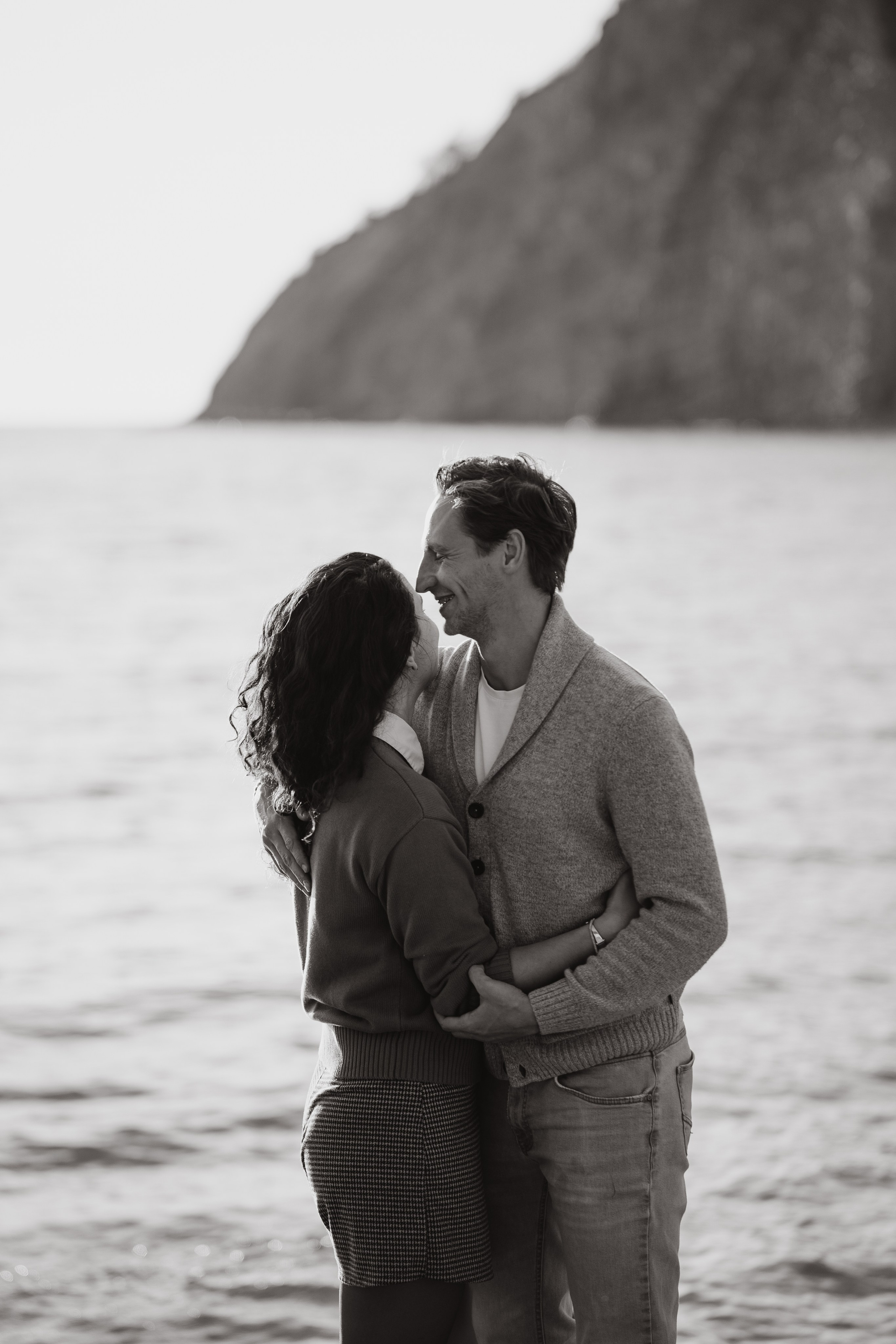 Черно-белая фотография семьи у моря. Фотограф Новороссийск запечатлел момент нежности между родителями и их детьми на пляже.