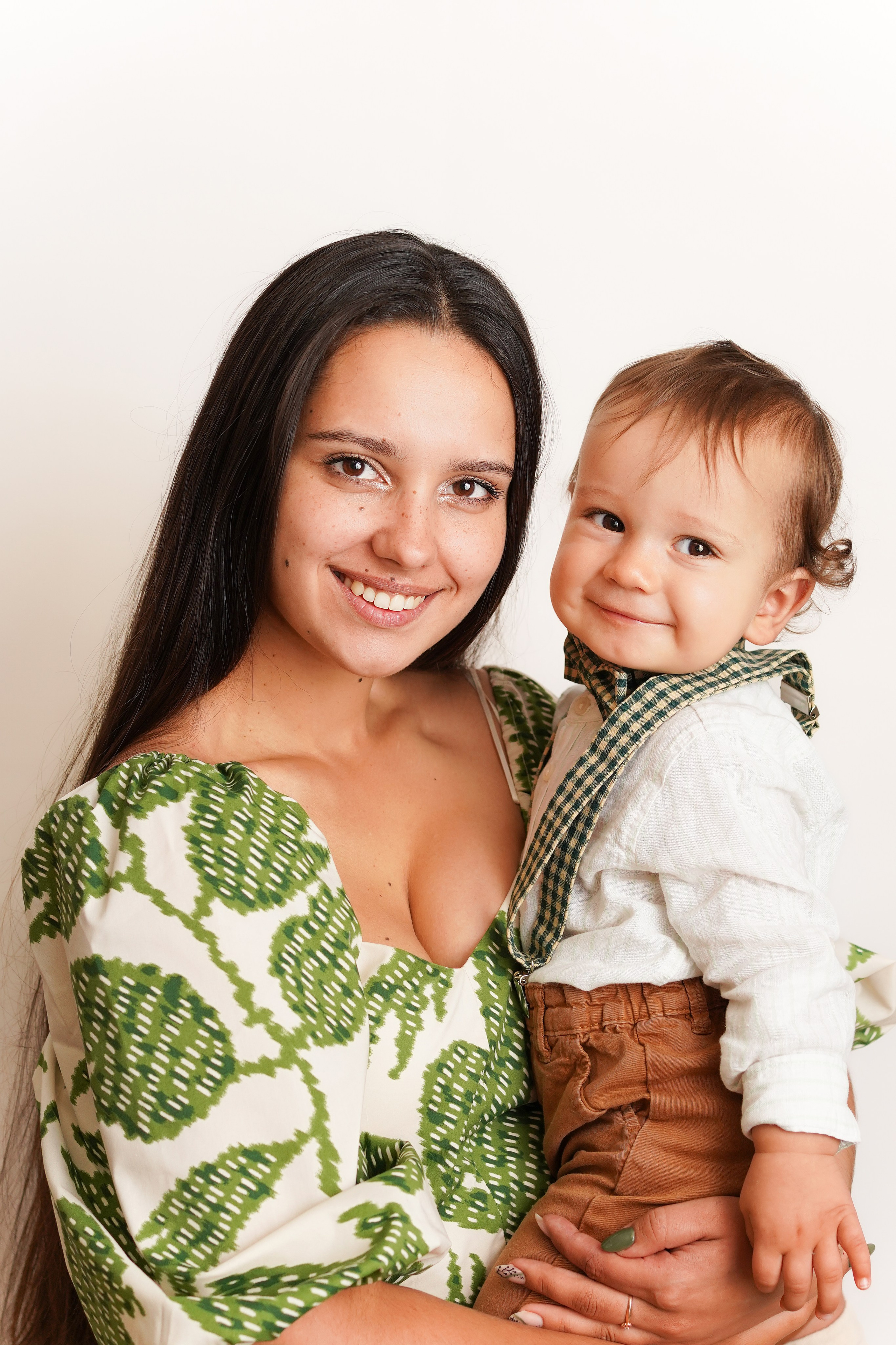 Портрет мамы в зеленом платье с сыночком на руках. На малыше красивый костюм, бабочка, подтяжки.