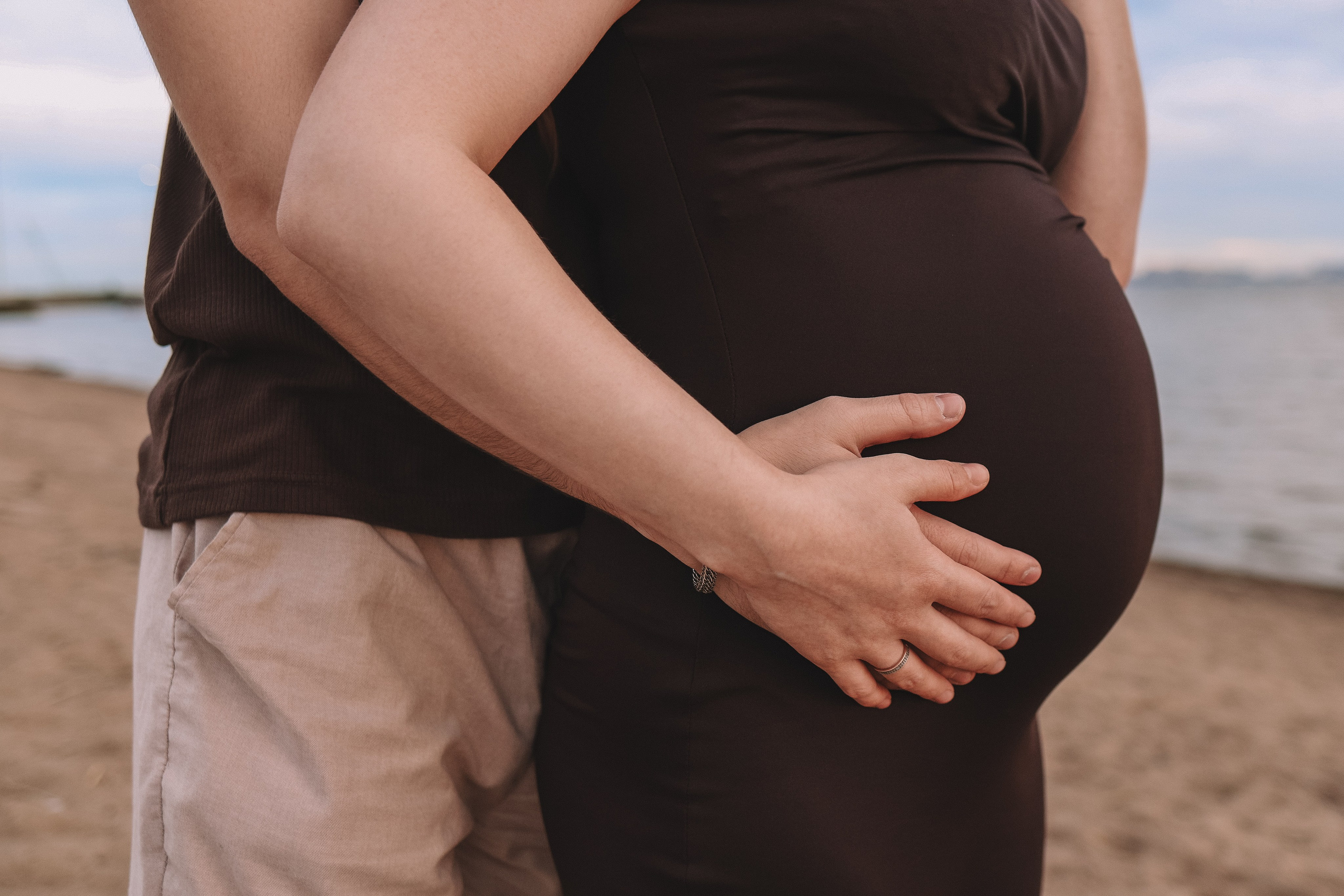 Мужчина держит живот беременной, крупный план, фотосессия