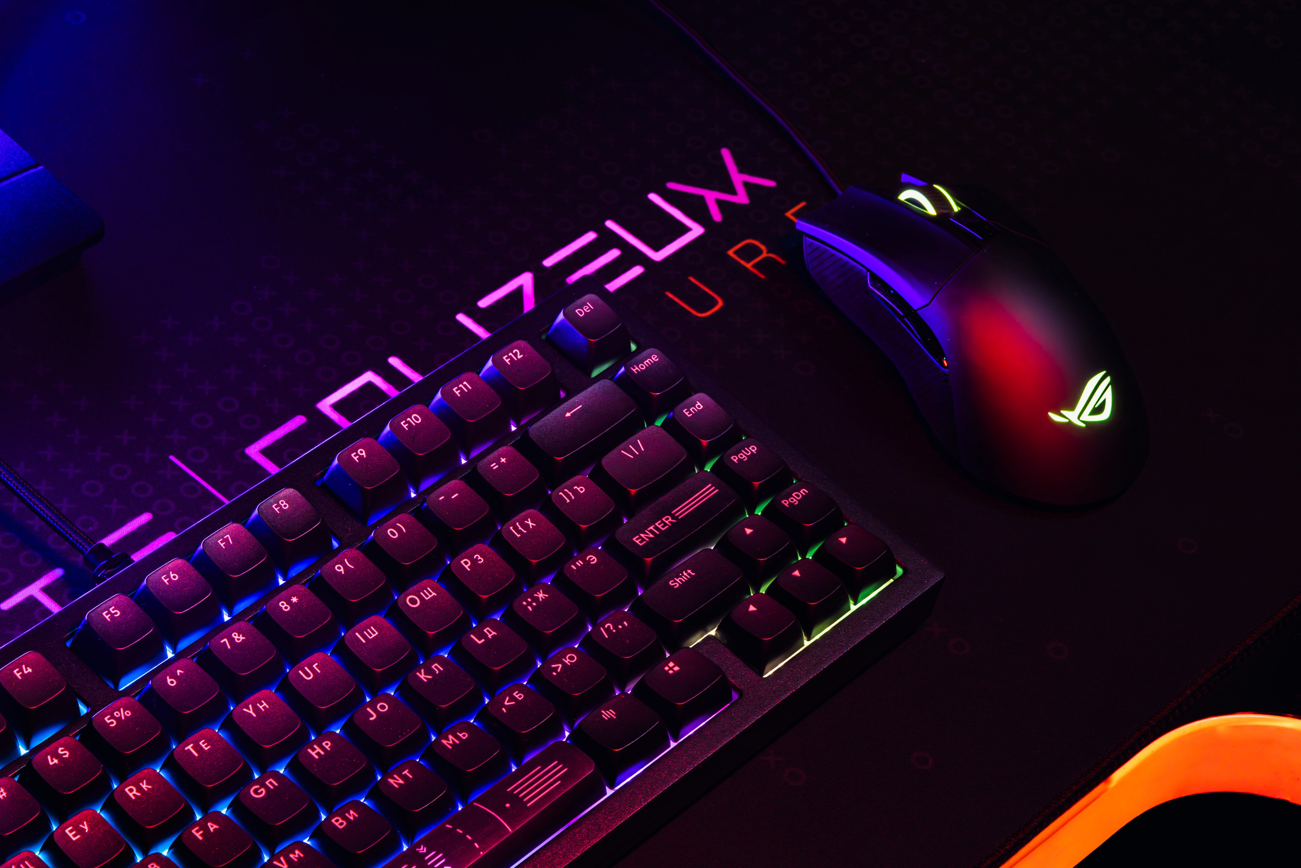 Макрофото: текстура клавиатуры и мыши на игровом месте, акцент на материалах.