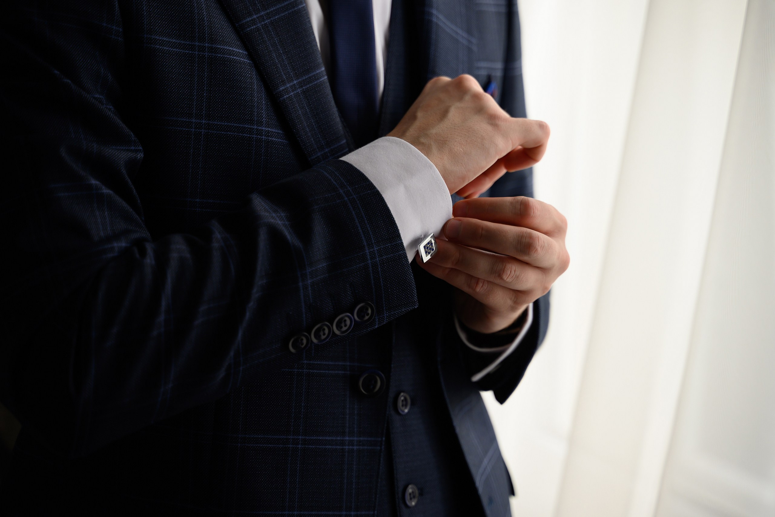 Жених надевает запонки.