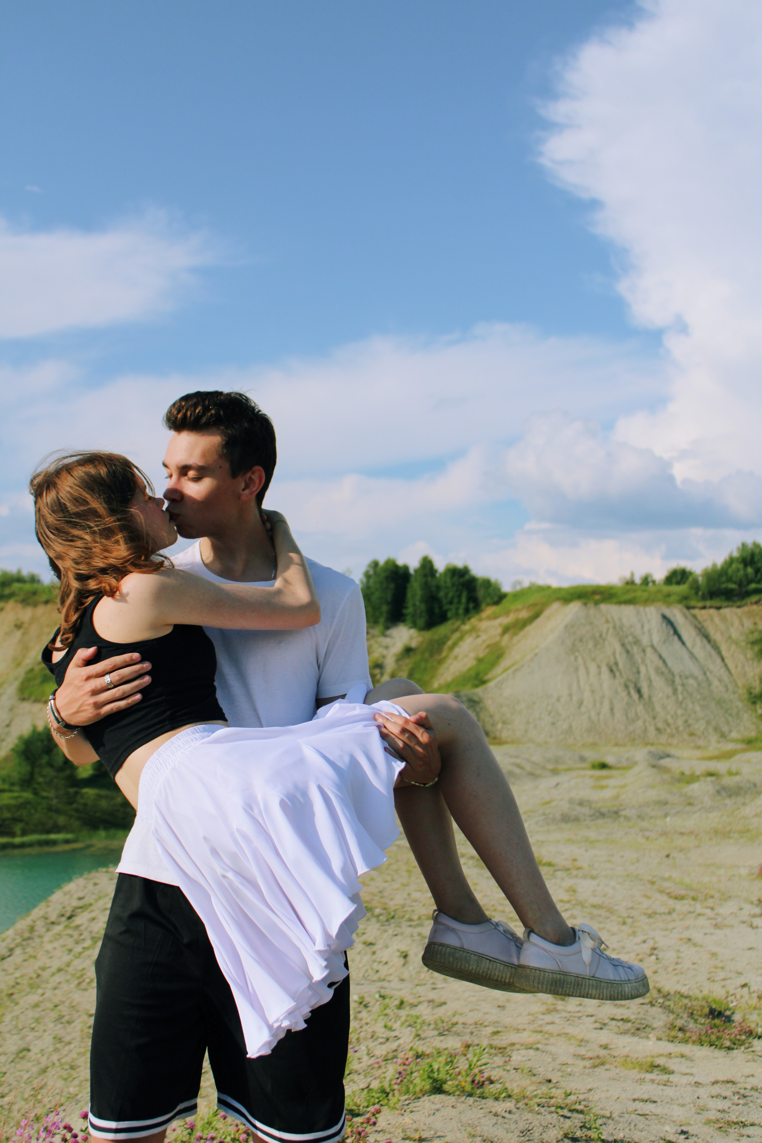 Парень и девушка. Семейная пара стоит вместе. Он держит ее на руках