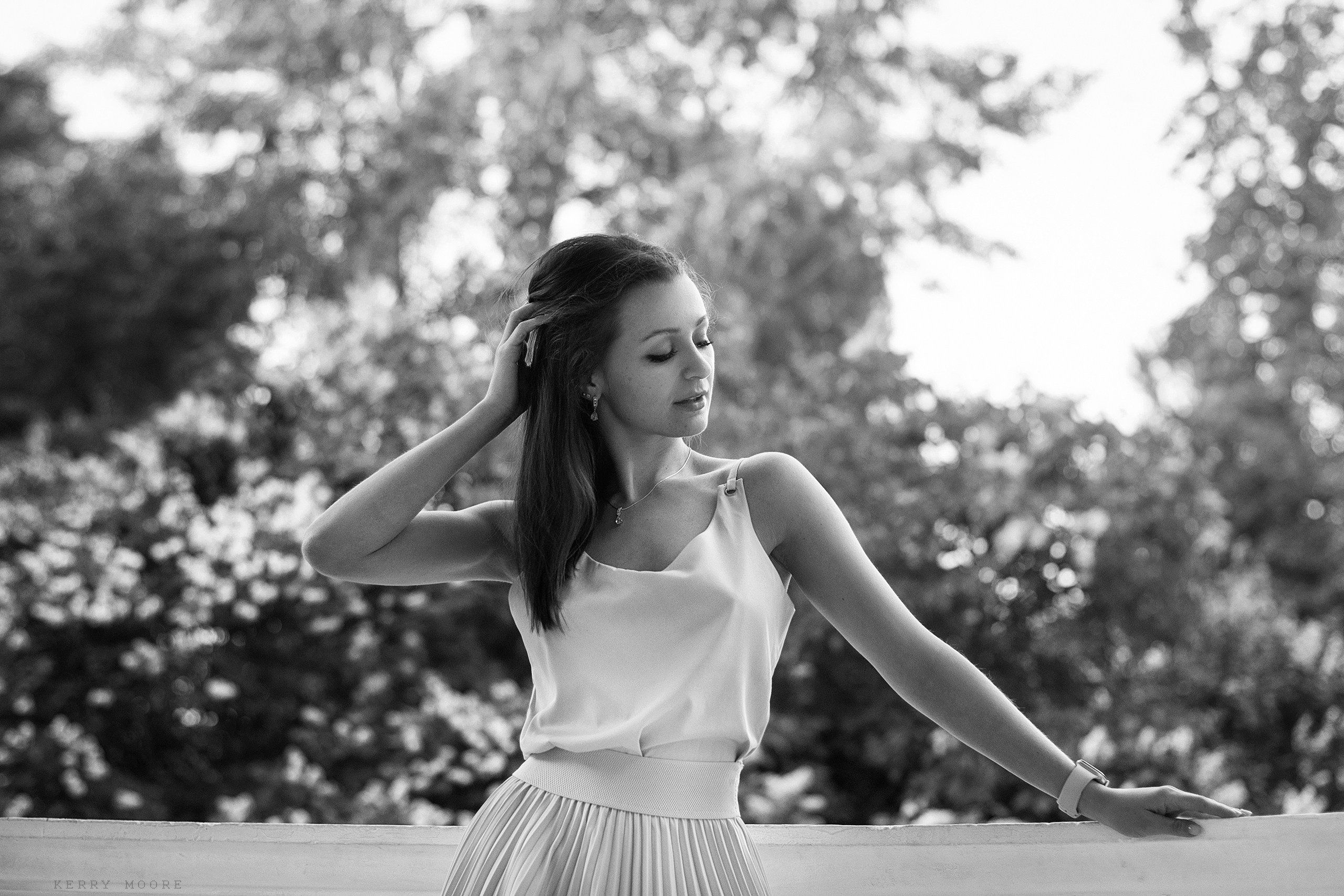 Красивая девушка задумчиво стоит облокотившись на беседку