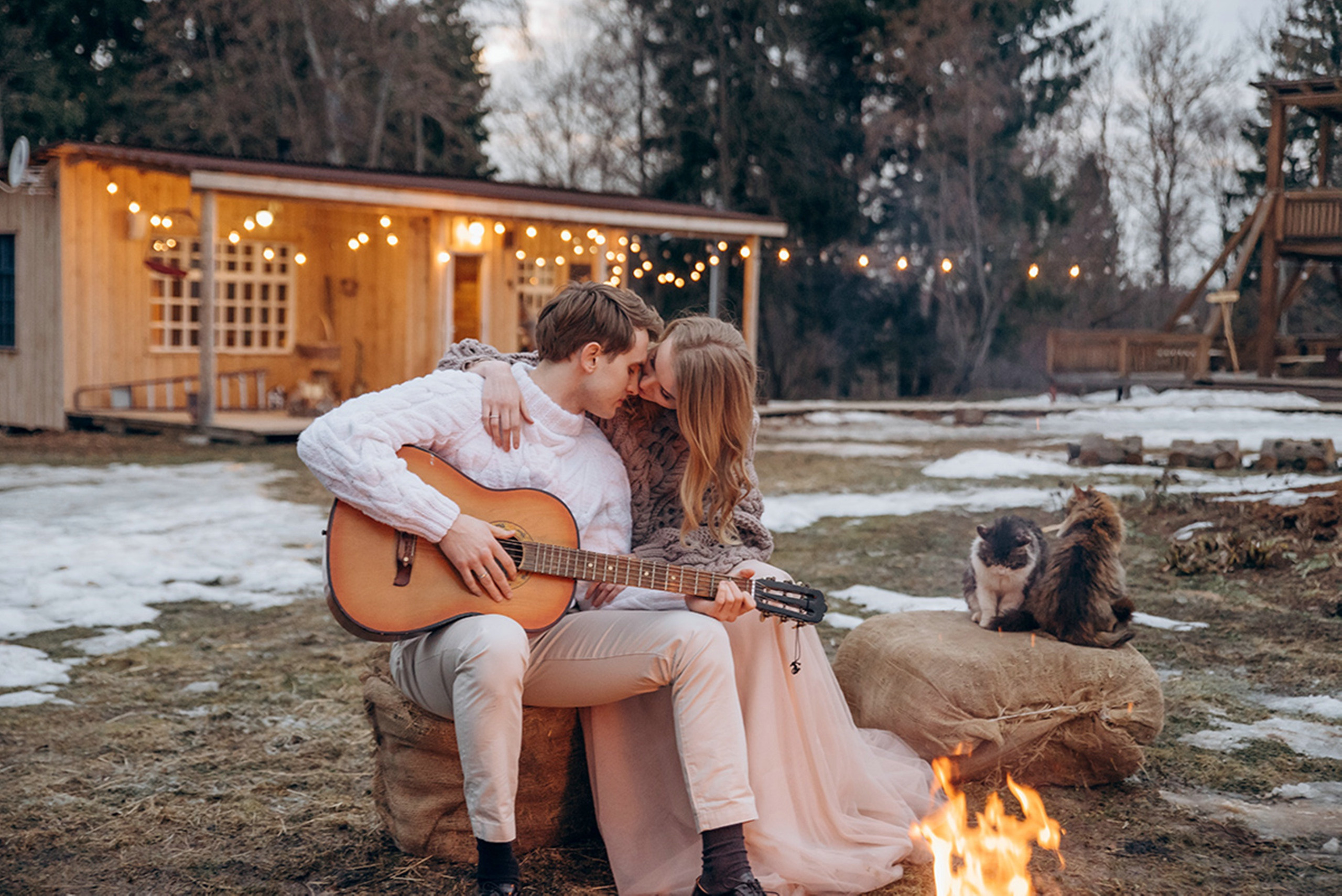Жених поет песню невесте, играя на гитаре у костра.