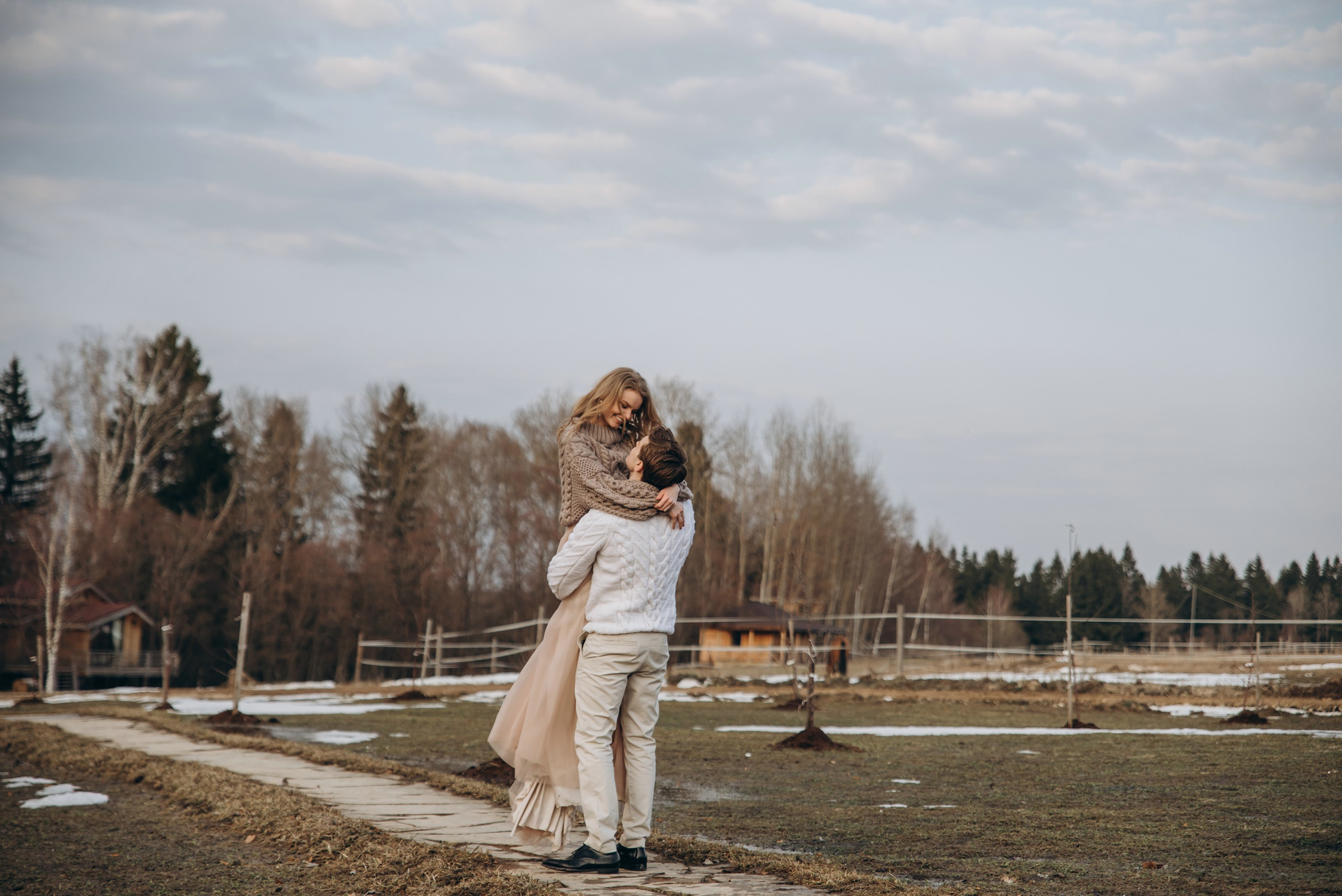 Жених поднимает невесту на руки и кружит ее