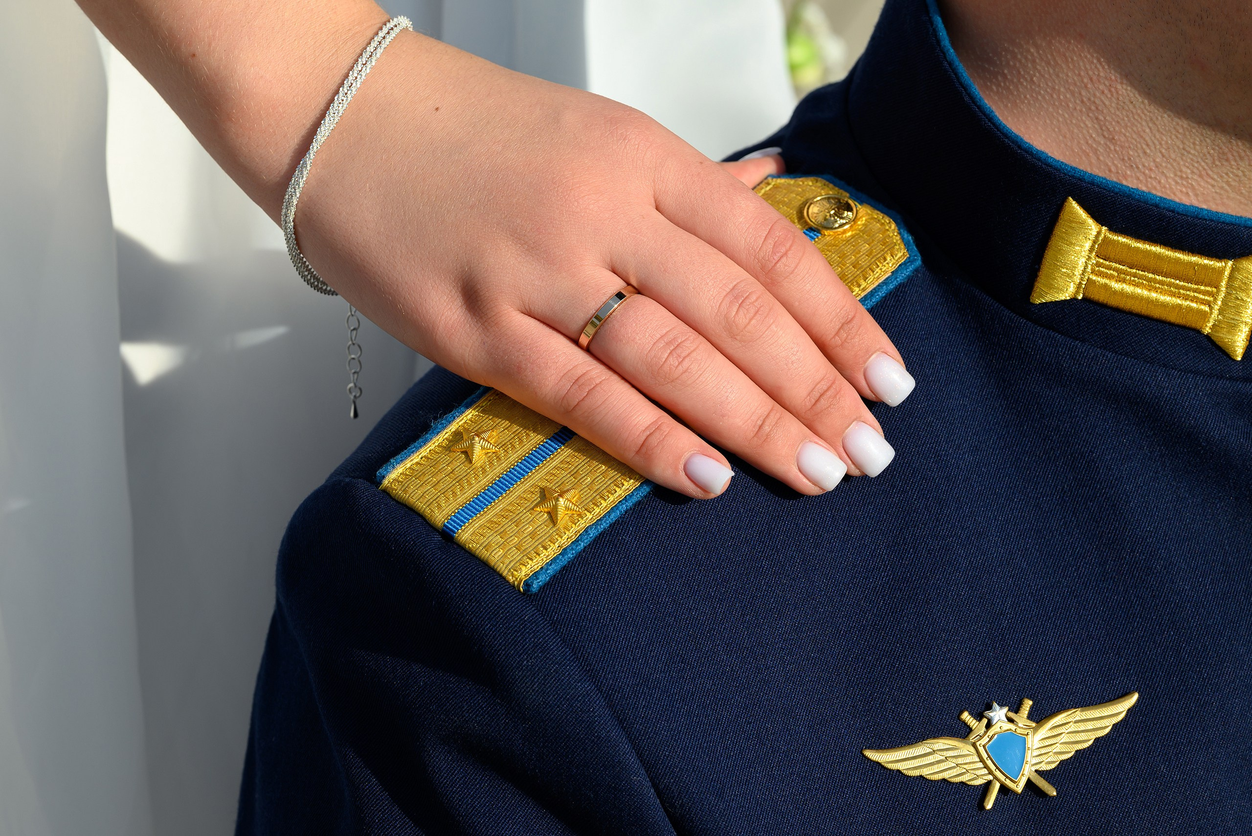 Невеста кладет руку с кольцом на офицерский погон.