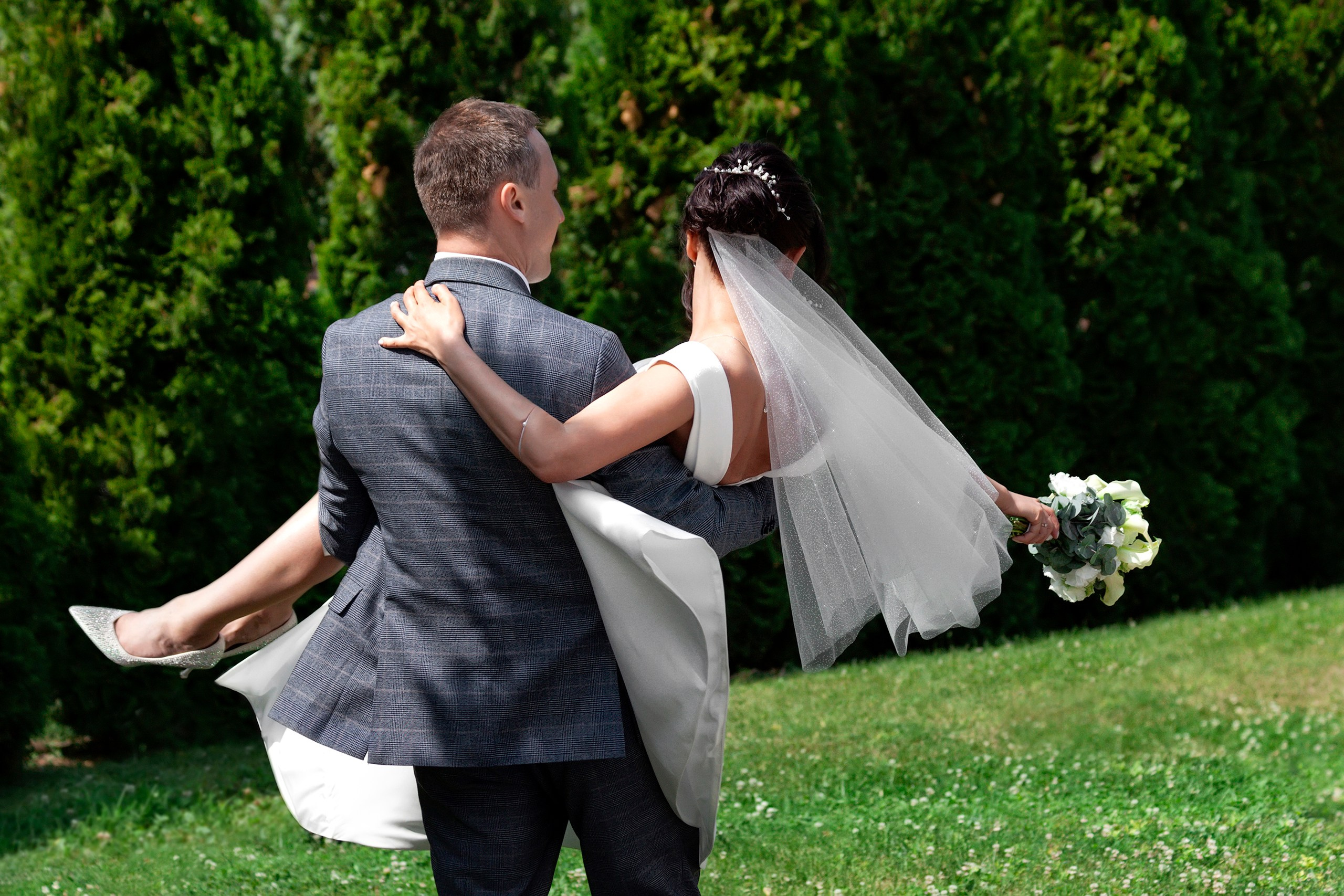 Жених крутит невесту на руках в парке