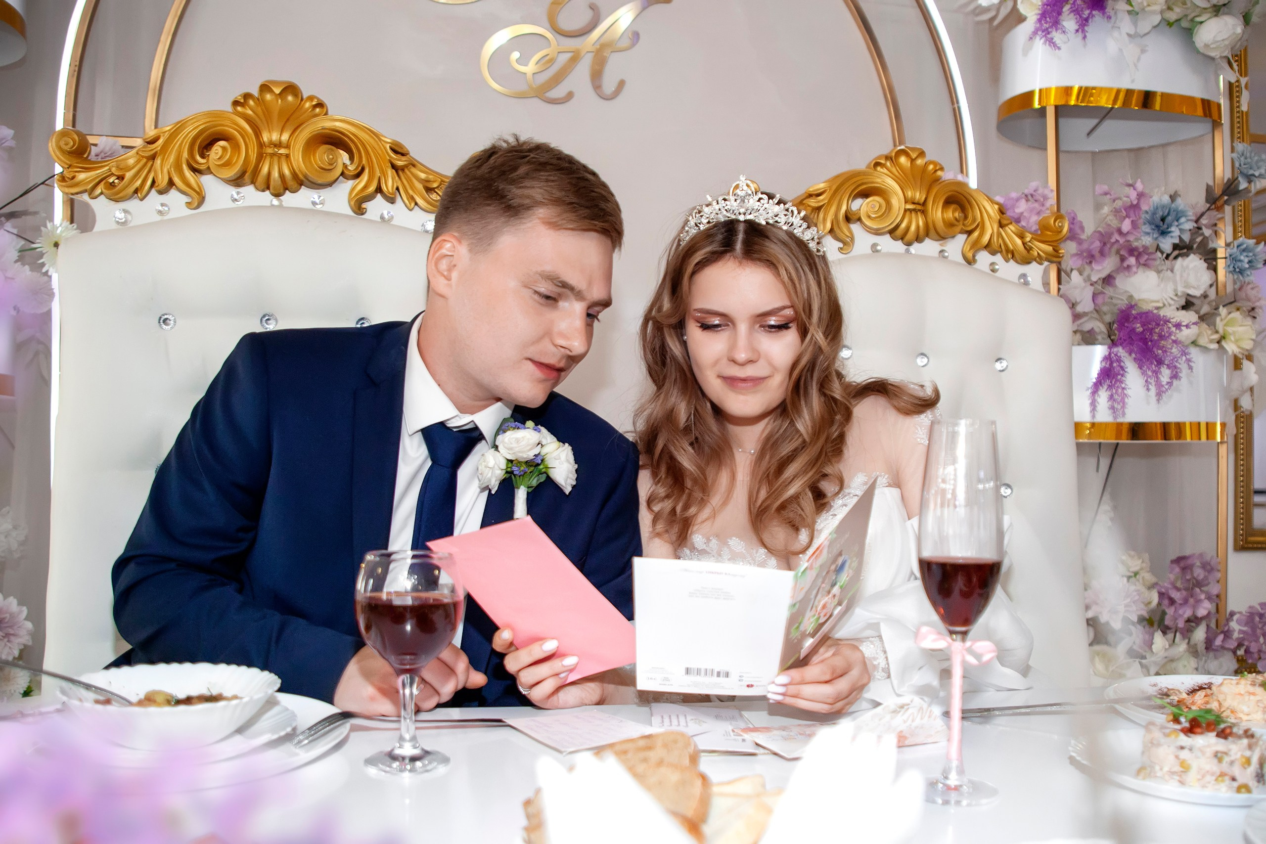 Молодожёны рассматривают подарки гостей на свадебном банкете