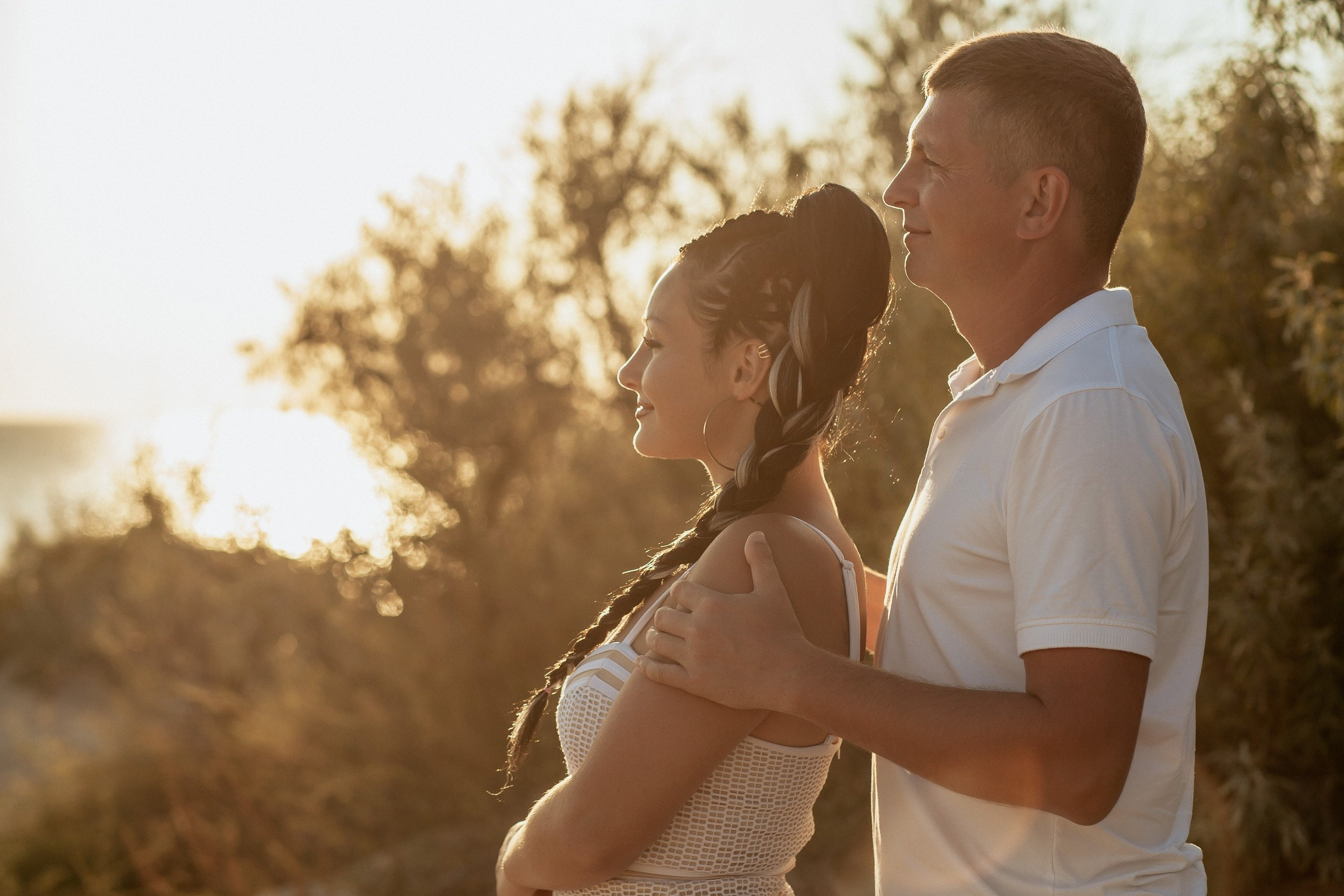Семейная пара на закате позируют для фотографа. 