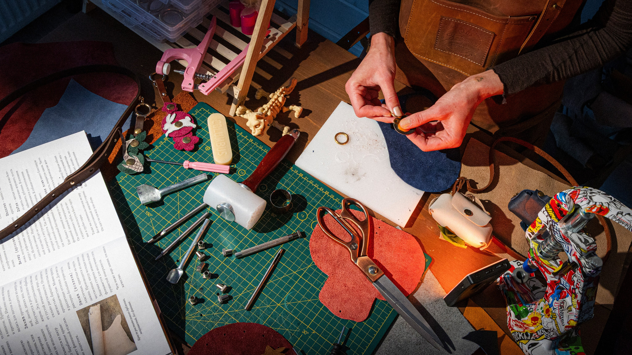 Мастер примеряет фурнитуру к готовому кошельку, проверяет посадку.