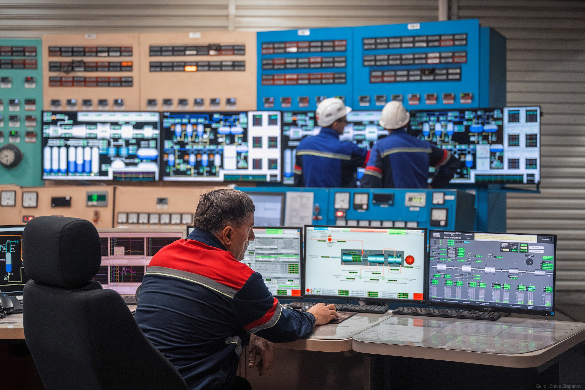 Современный щит управления Красноярской ТЭЦ-2 с цифровыми мнемосхемами и дежурными операторами за работой, кадр Gelio.