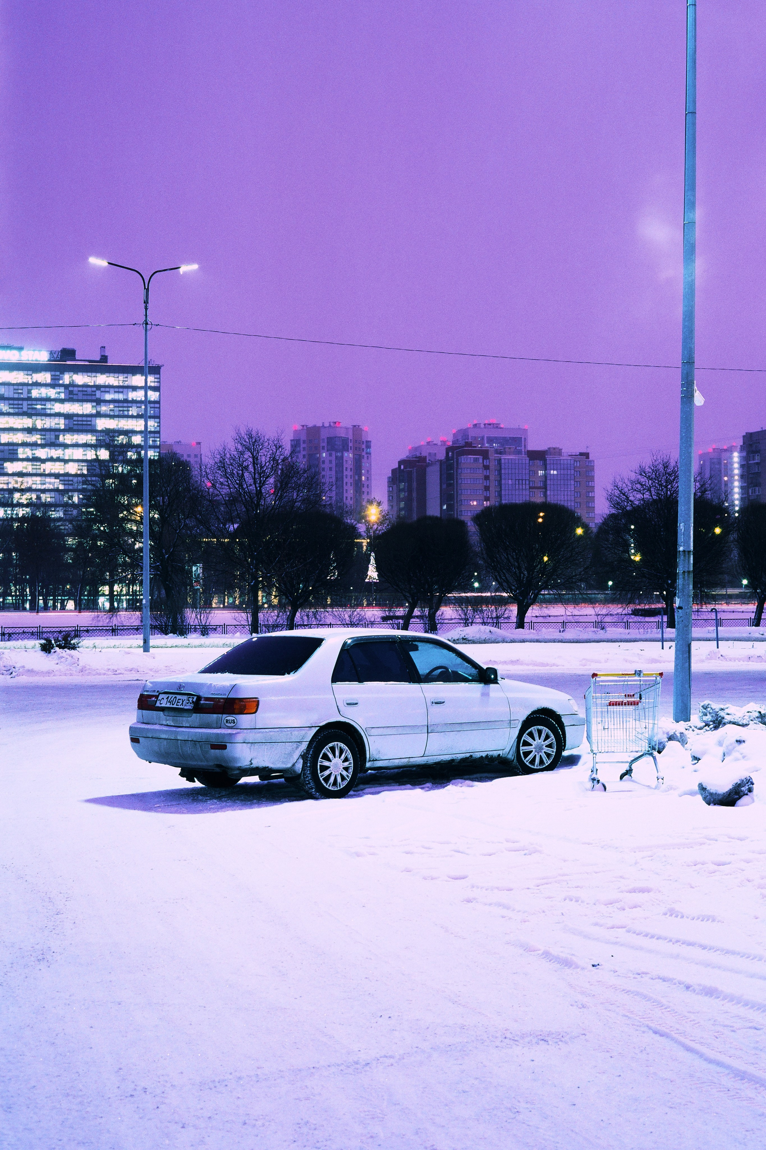 Ночной вид на снежную автомобильную парковку у гипермаркета. Санкт-Петербург, Россия