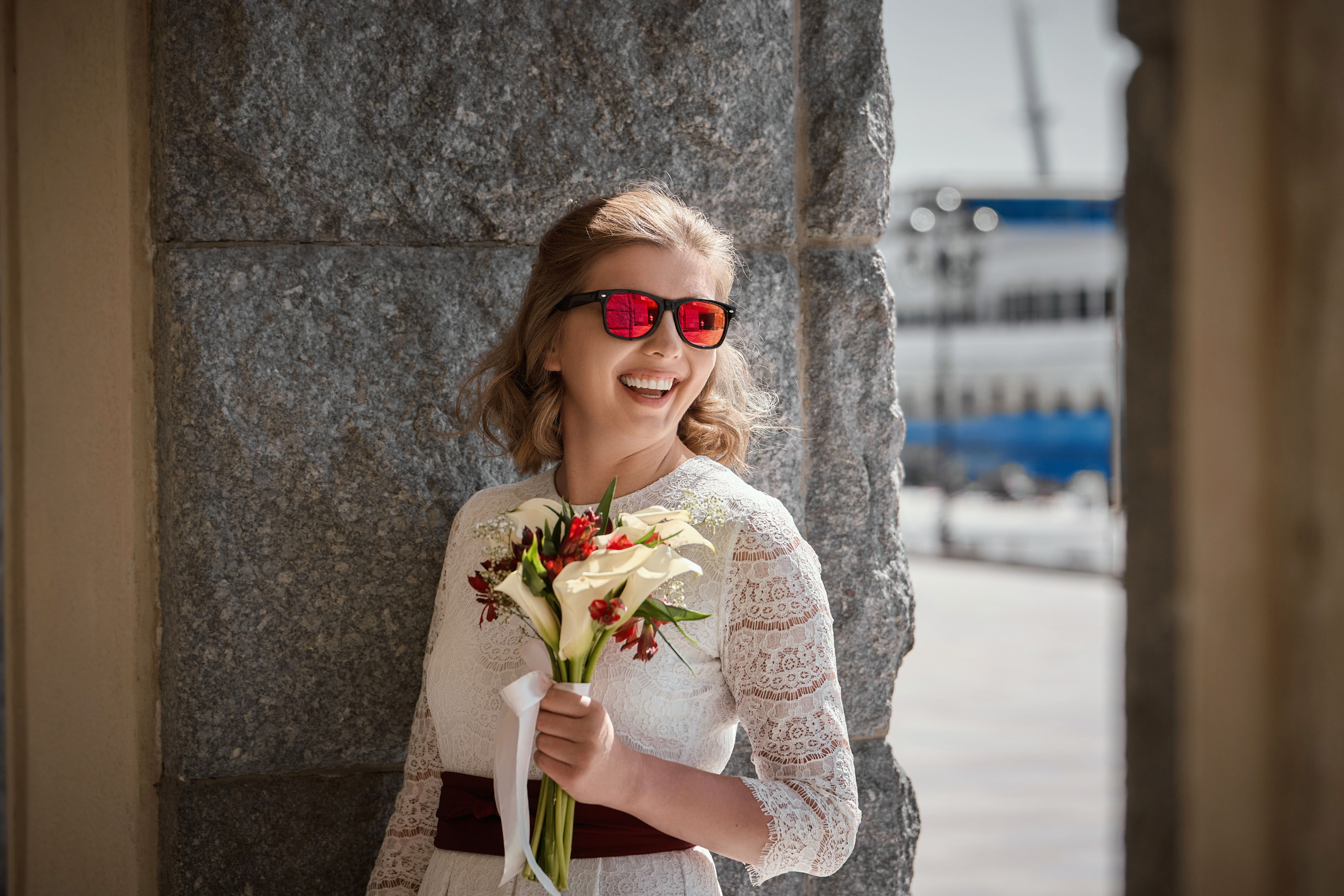 невеста в красных очках и свадебным букетом у касс речного вокзала с видом на Москва реку