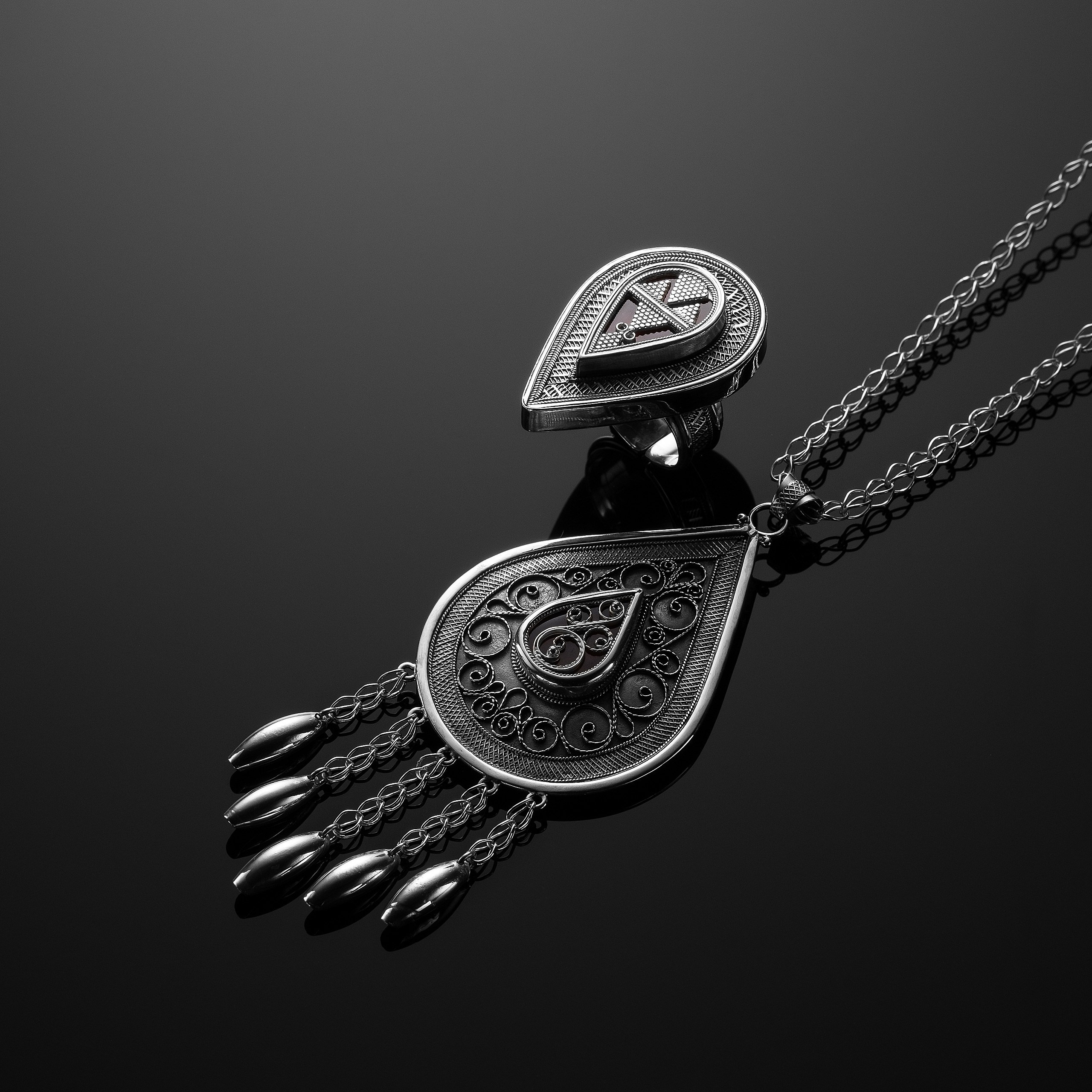 Рекламная фотосъёмка украшений Ornek — крупный план традиционного кулона с элементами «қол» в серебре. Профессиональная съёмка для каталога и выставки.