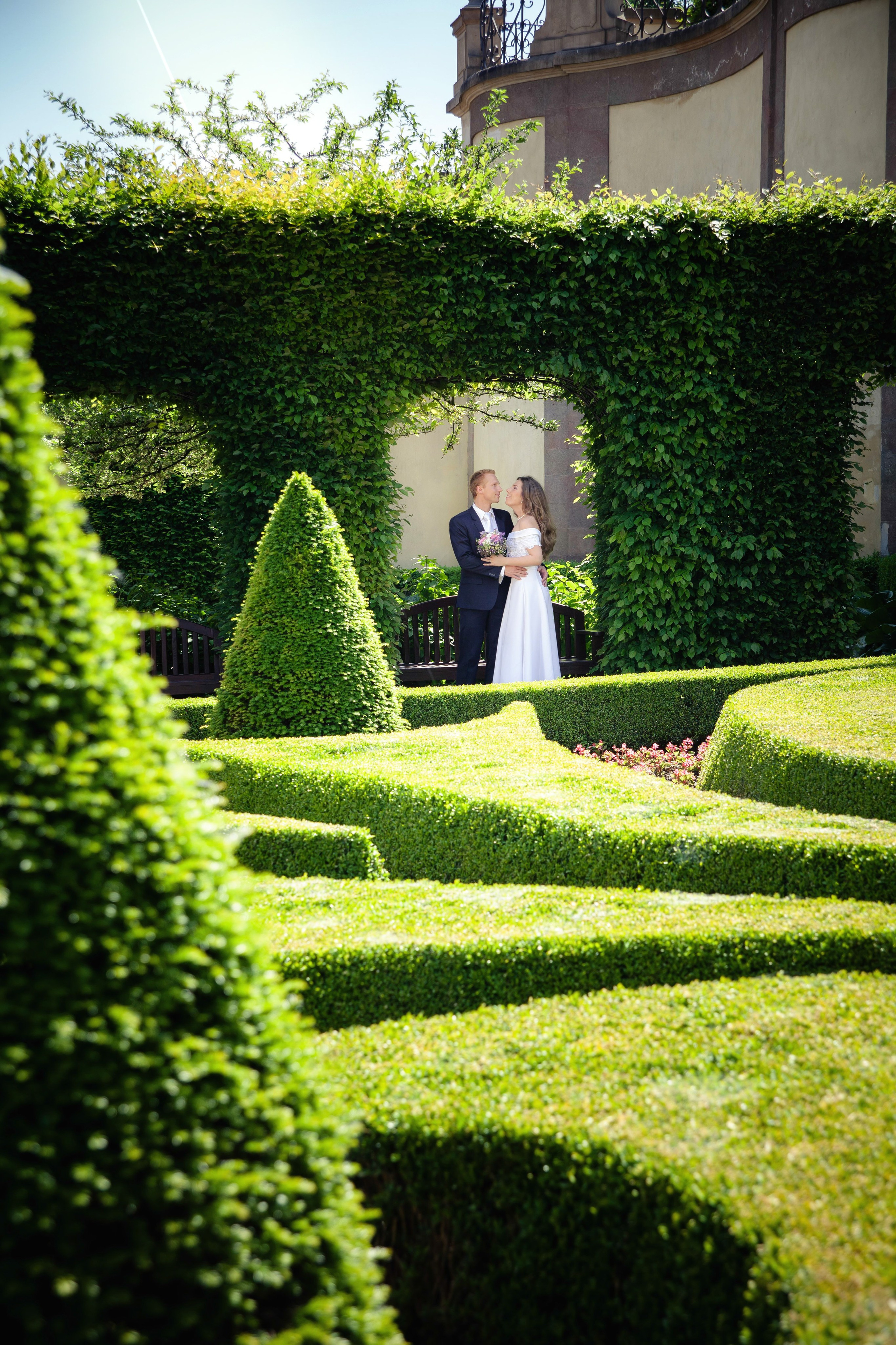 Жених и невеста в красивой локации с зеленым лабиринтом.