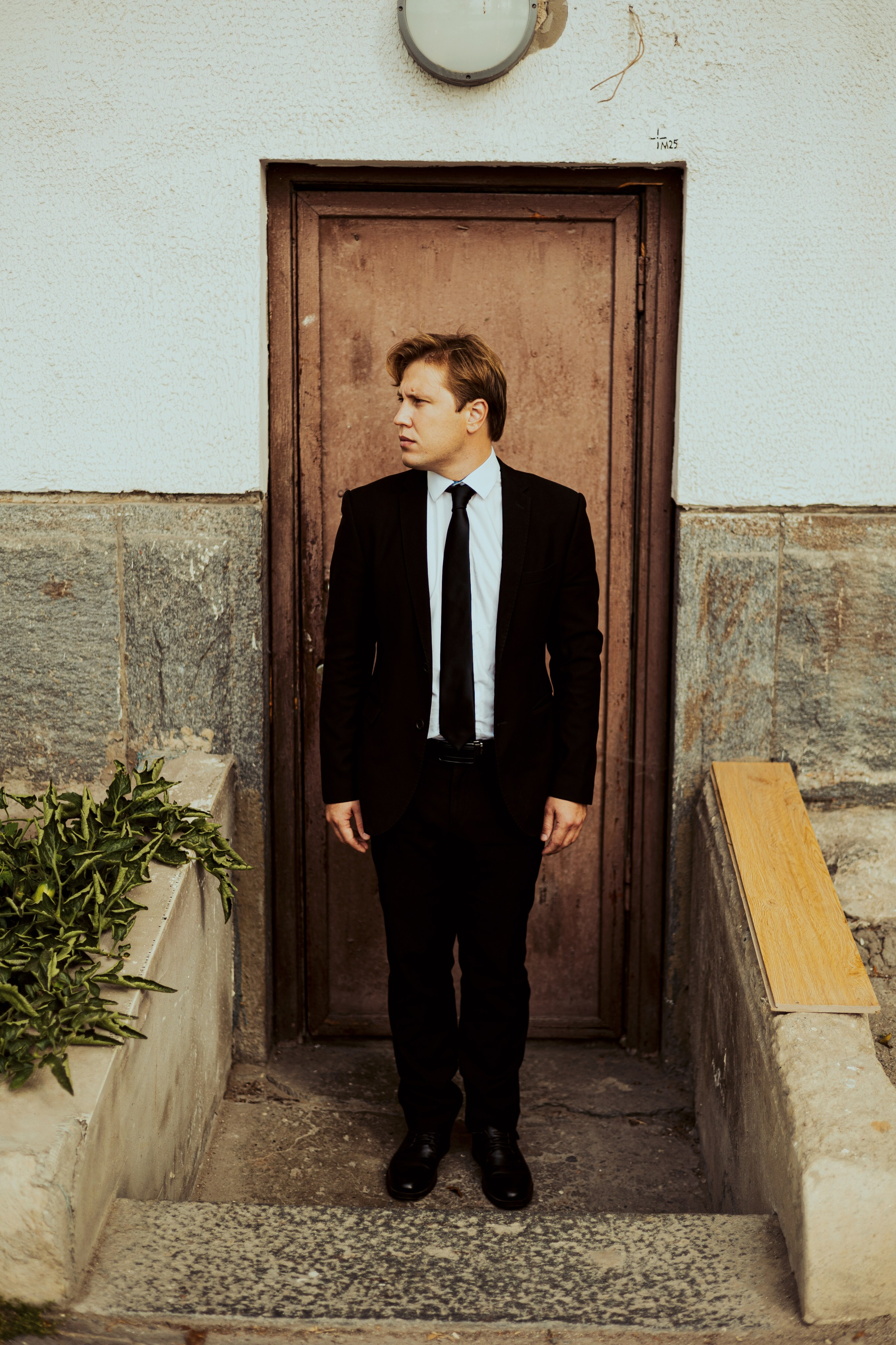 Мужчина спускается стоит в костюме в профиль