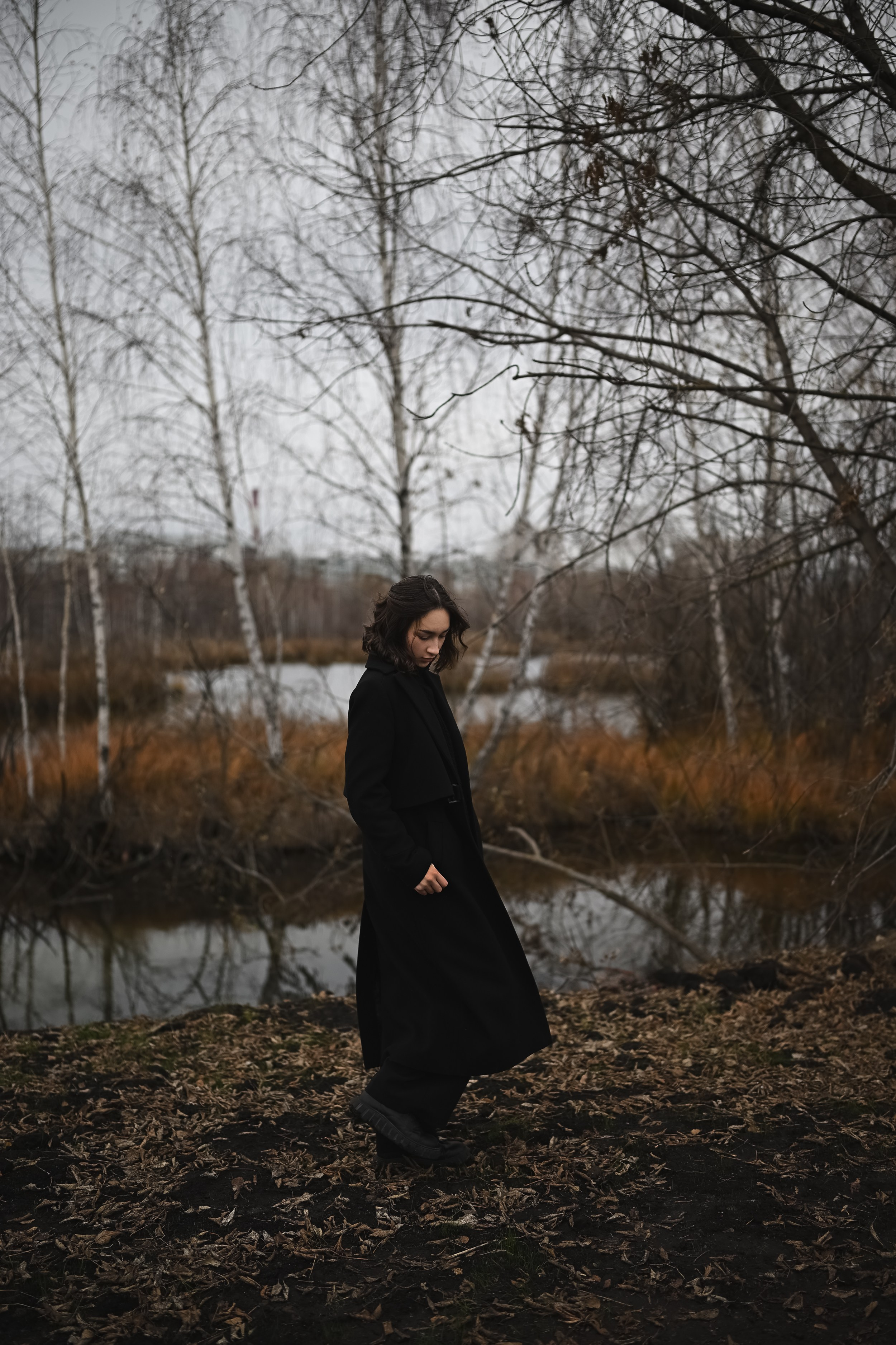 Девушка в черном пальто в осеннем пейзаже Казани в рамках природной фотосессии