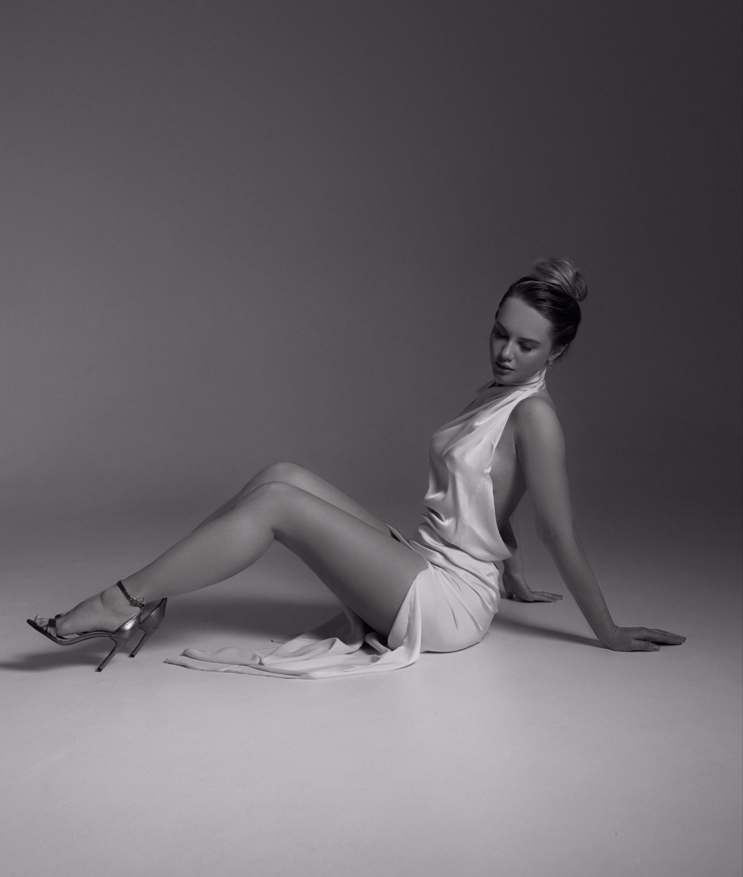 Девушка модель в белом платье на циклораме