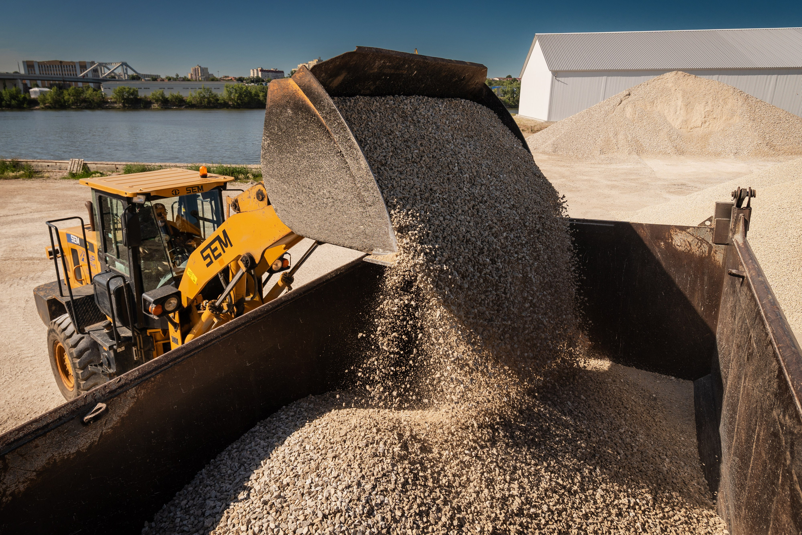 Загрузка щебня в кузов самосвала в карьере