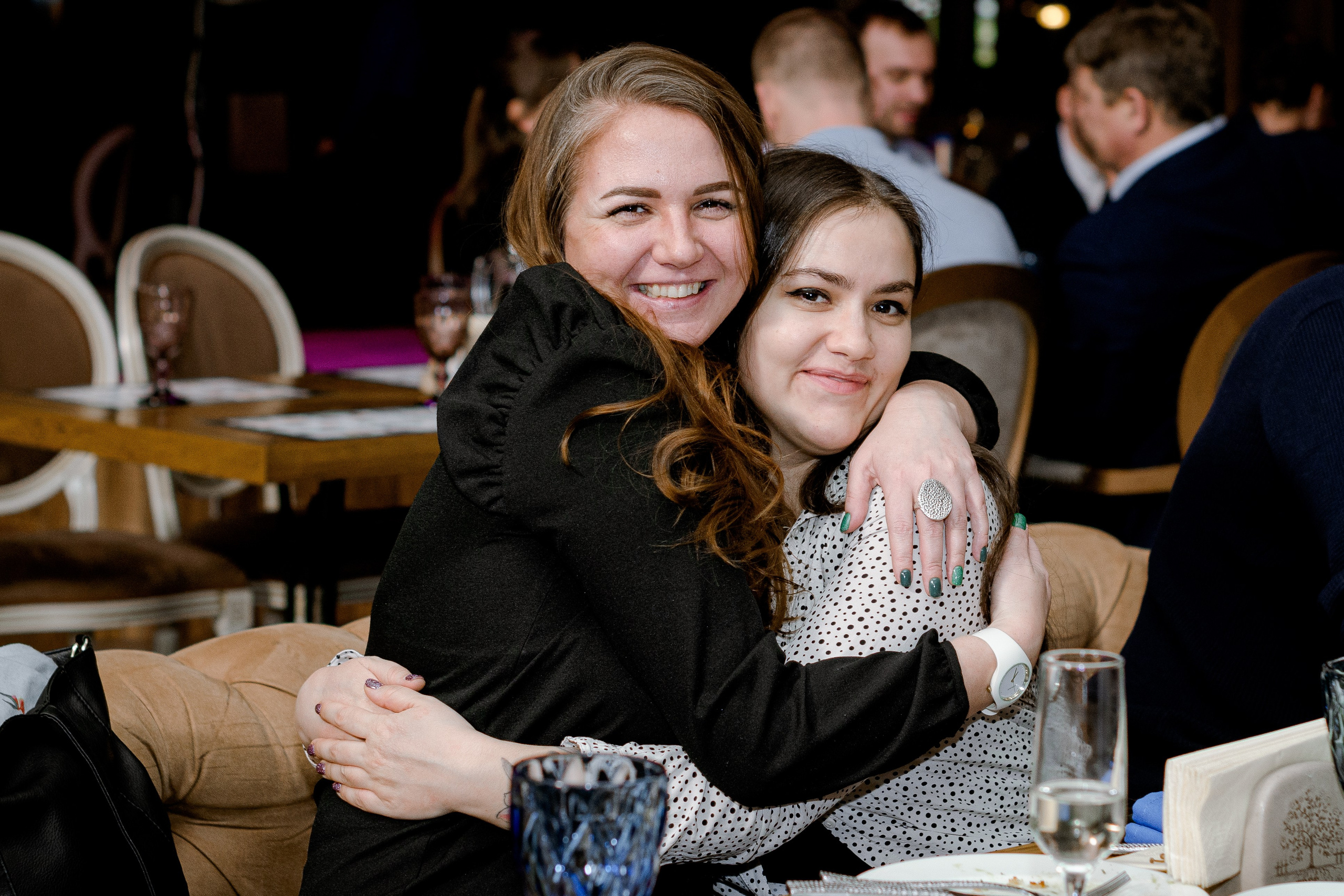 две девушки обнимаются за праздничным столом