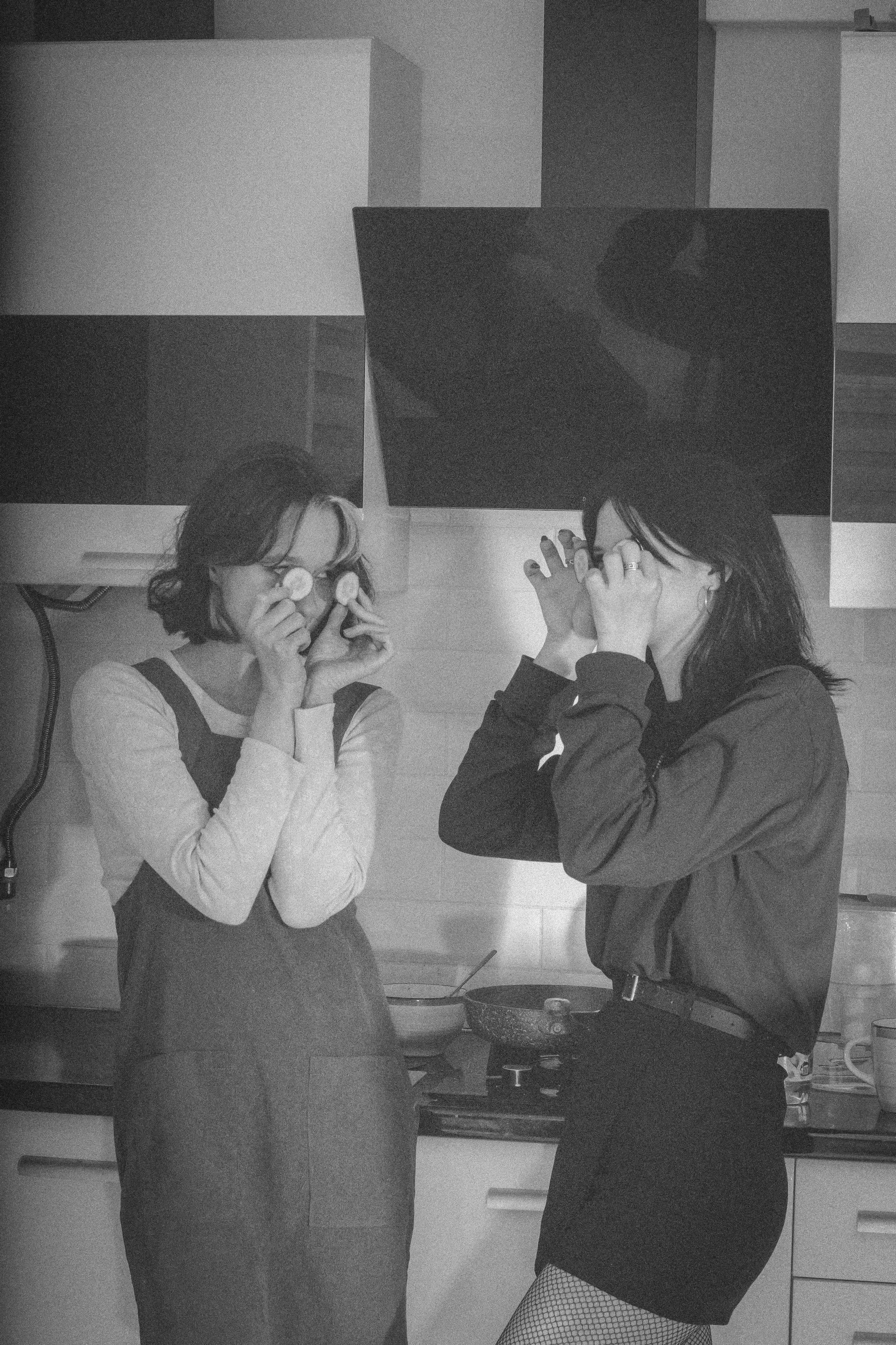 Две девушки шутят на кухне, прикладывая кружочки к глазам — простая радость, которую уже не вернуть.