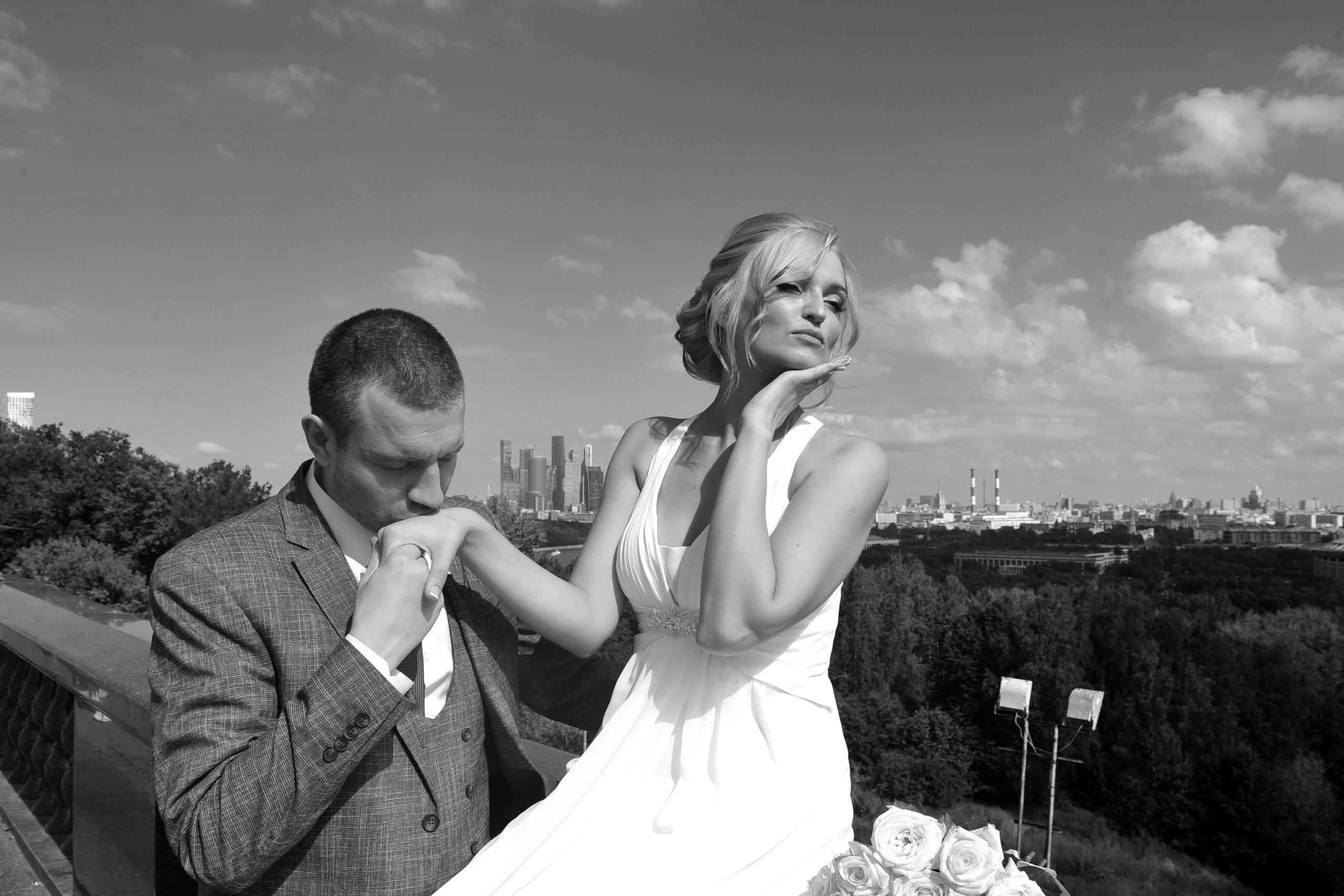 Свадьба на Воробьёвых Горах рядом с МГУ, жених целует руку невесты, невеста отворачивается, черно-белая фотография