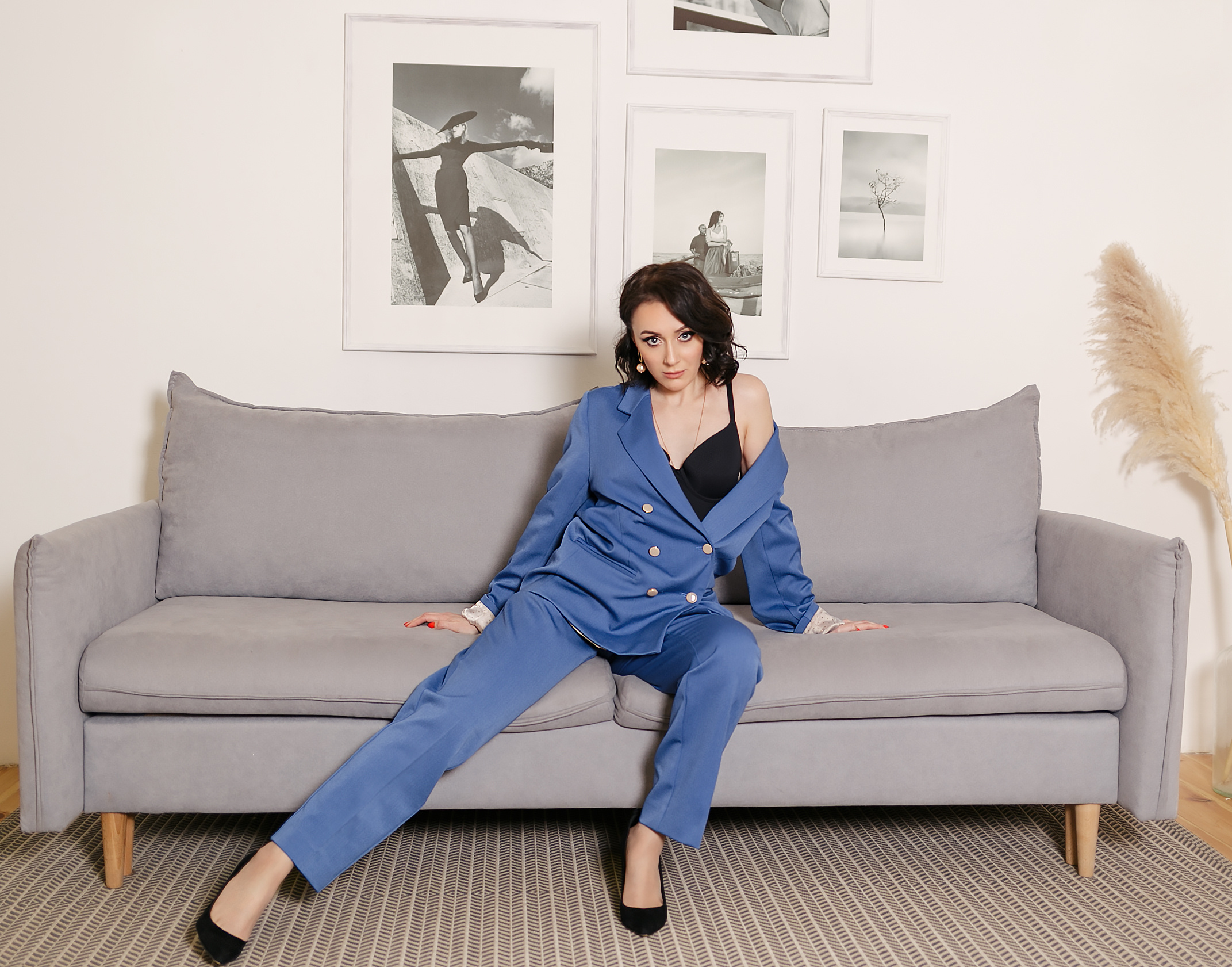 Рекламная фотосъёмка в брючном синем костюме с позированием на диване