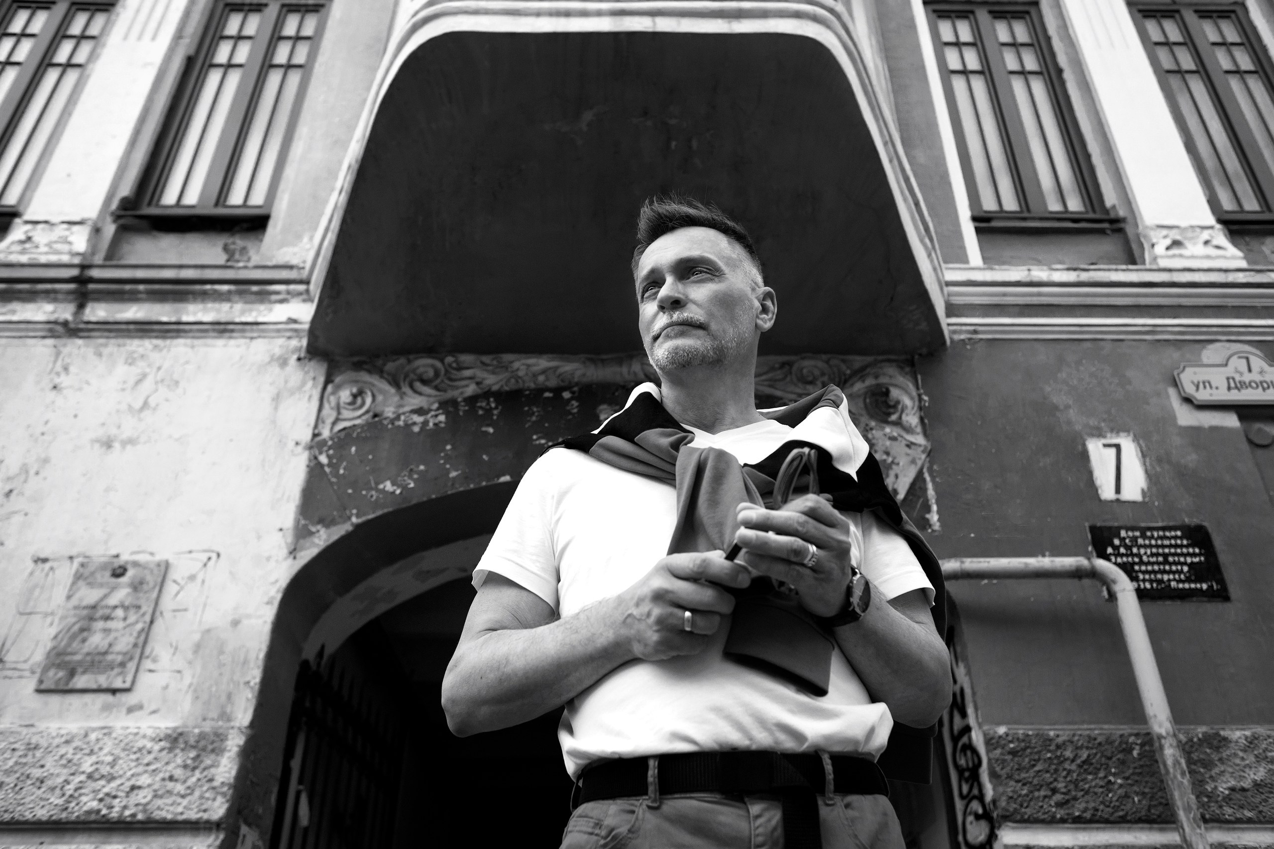 Черно-белый портрет мужчины на фоне здания