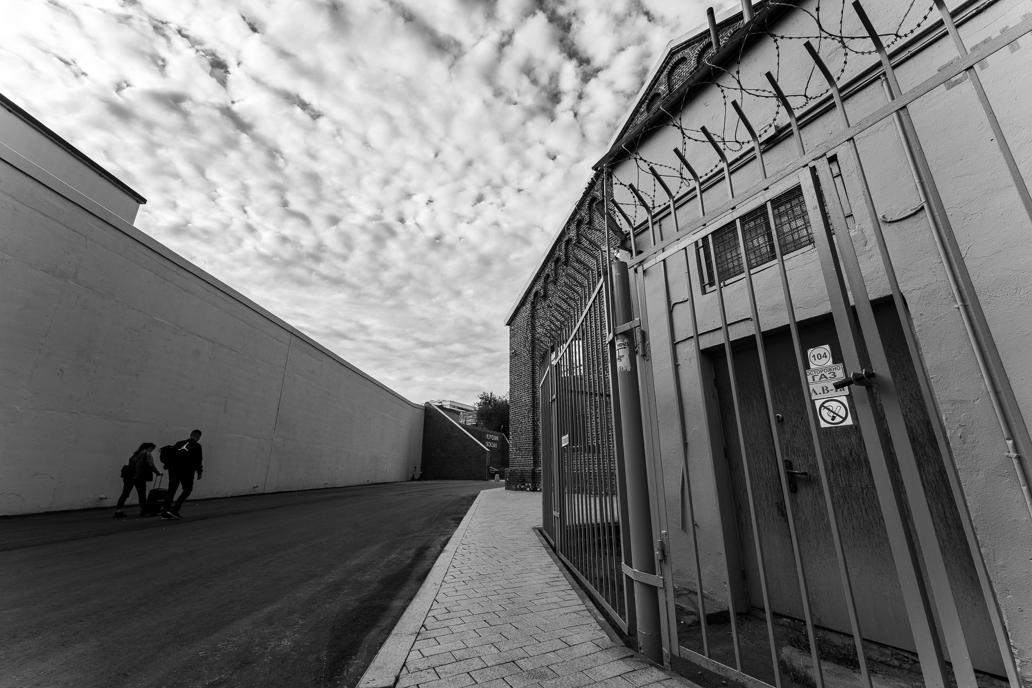 Двое людей идут на фоне стены в Арме