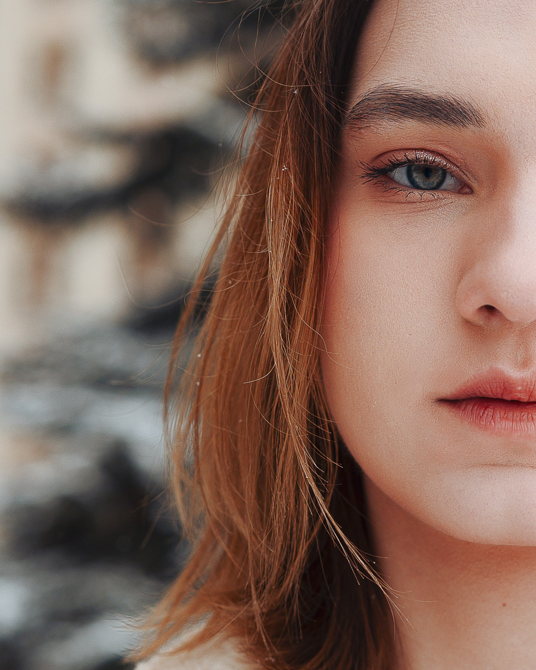 Женский портрет на улице, зимняя атмосфера, тёплая одежда, светлый шарф, фон с архитектурой, супер крупный план